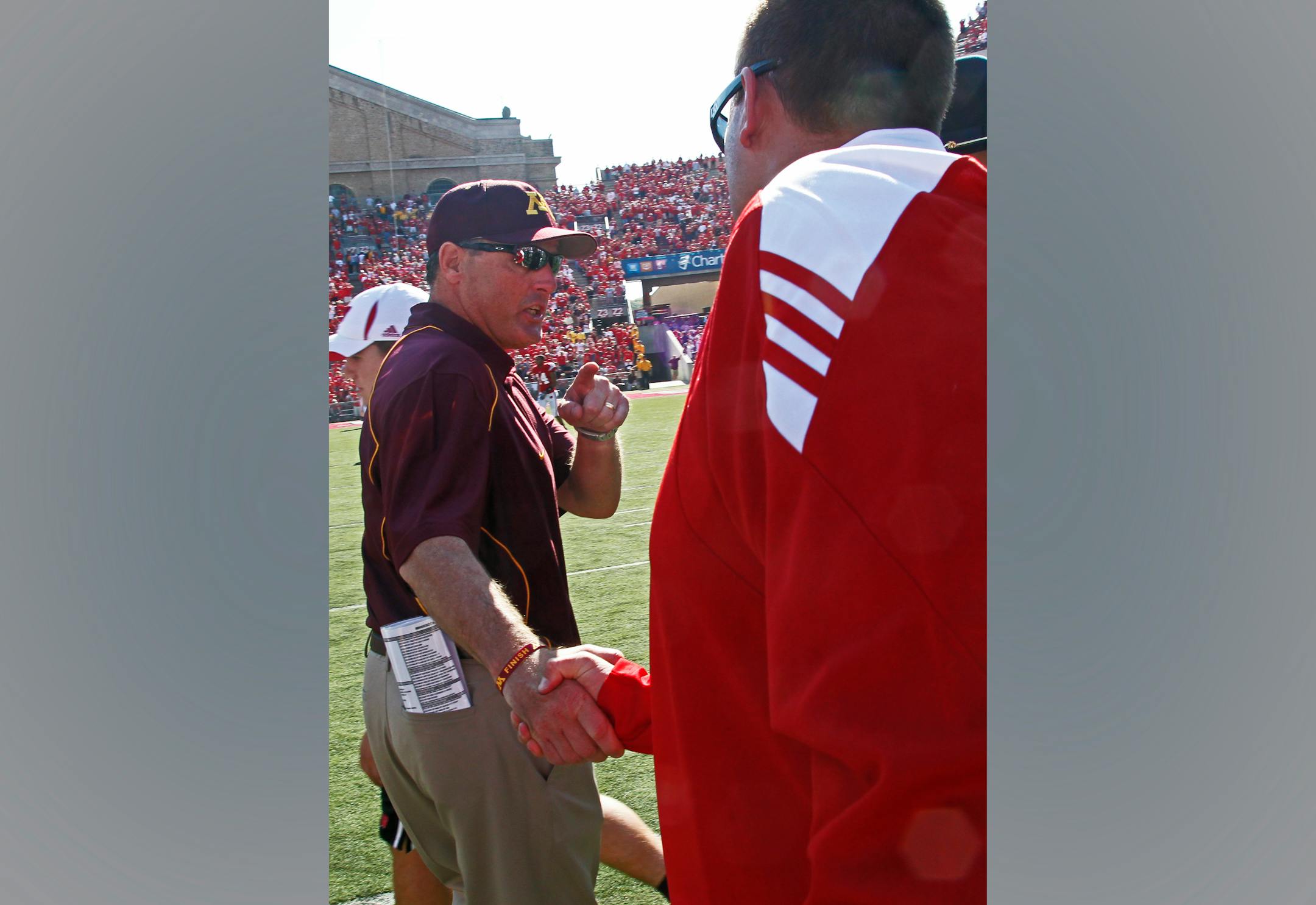 ]MARLIN LEVISON * mlevison@startribune.com October 9, 2010 - GENERAL INFORMATION: University of Minnesota vs. Wisconsin football. Wisconsin won 41-23. IN THIS PHOTO: Minnesota head coach Tim Brewster, left was "not happy" as he made the traditional mid-field shaking of hands with the opposing coach - Wisconsin head coach Bret Bielema. Brewster told Bielema that going for two points conversion after a touchdown with a huge lead in the 4th quarter was not necessary and that "the Gophers would be back".