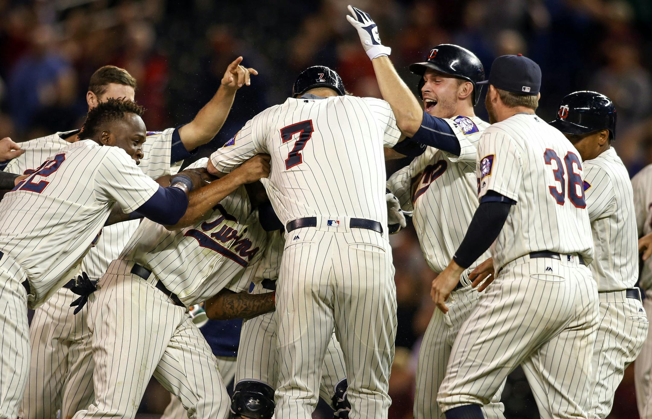 Teammates surround Minnesota Twins' Joe Mauer (7) after he hit in Brian Dozier to defeat the Cleveland Indians in twelve innings at a baseball game Saturday, Sept. 10, 2016, in Minneapolis. (AP Photo/Bruce Kluckhohn)