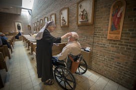 Sister Mary Alphonsus marked an ashen cross on the forehead of a resident and others in the chapel during the Ash Wednesday Mass at Little Sisters of 