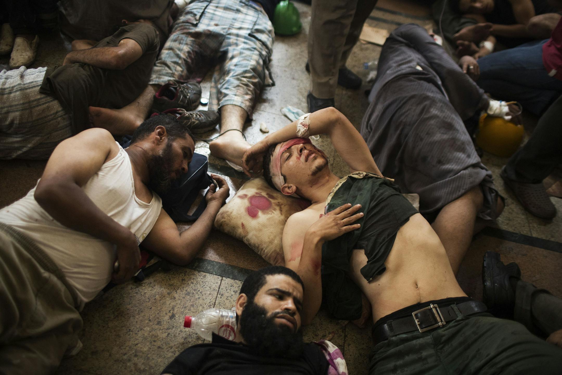 FILE - In this Wednesday, Aug. 14, 2013 file photo, Wounded supporters of ousted Islamist President Mohammed Morsi lie on the floor of a makeshift hospital at a sit-in at Cairo's Nasr City district, Egypt. The scene on Aug. 14, 2013, was the start of the biggest massacre in modern Egyptian history, at least 624 people were killed during 12 hours of mayhem in Cairoís Rabaah el-Adawiyah Square, though rights groups have said the toll may be several hundred higher. (AP Photo/Manu Brabo, File)