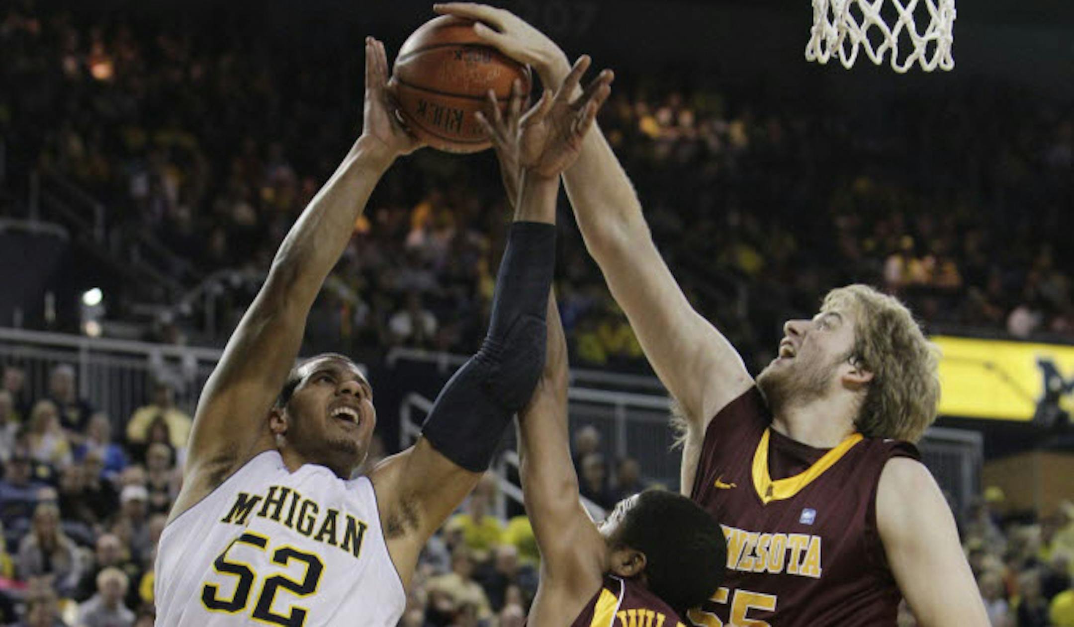 The Gophers' Elliott Eliason (55) blocked a shot by Michigan's Jordan Morgan (52).