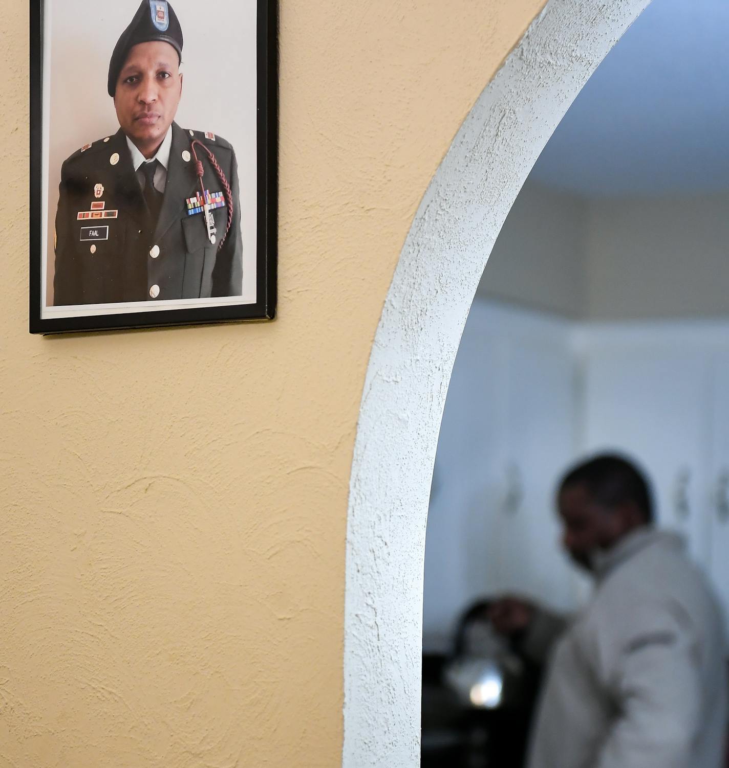 Papa Faal made tea in his kitchen before dinner Thursday night. On the wall, a portrait of Faal from his time spent in the United States Armed Forces. ] (AARON LAVINSKY/STAR TRIBUNE) aaron.lavinsky@startribune.com Almost two years ago, Papa Faal, a quiet family man, Army vet and IT instructor from Brooklyn Park, traveled to Gambia and took part in armed plot to overthrow the West African nation's ruler of more than two decades. After the coup failed, the U.S. government convicted Faal of taking