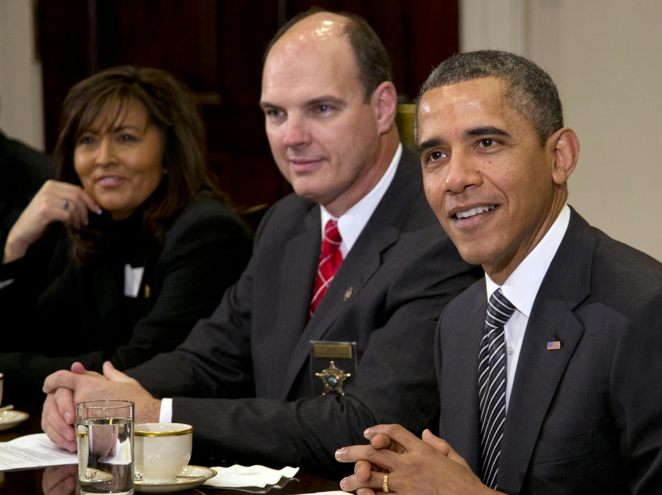 President Barack Obama pauses as the press leaves the room as he meets with representatives from Major Cities Chiefs Association and Major County Sheriffs Association in the Roosevelt Room of the White House, Monday, Jan. 28, 2013, in Washington, to discuss policies put forward by President Obama to reduce gun violence. From left are Minneapolis Police Chief Janee Harteau and Hennepin County Minnesota Sheriff Richard W. Stanek .
