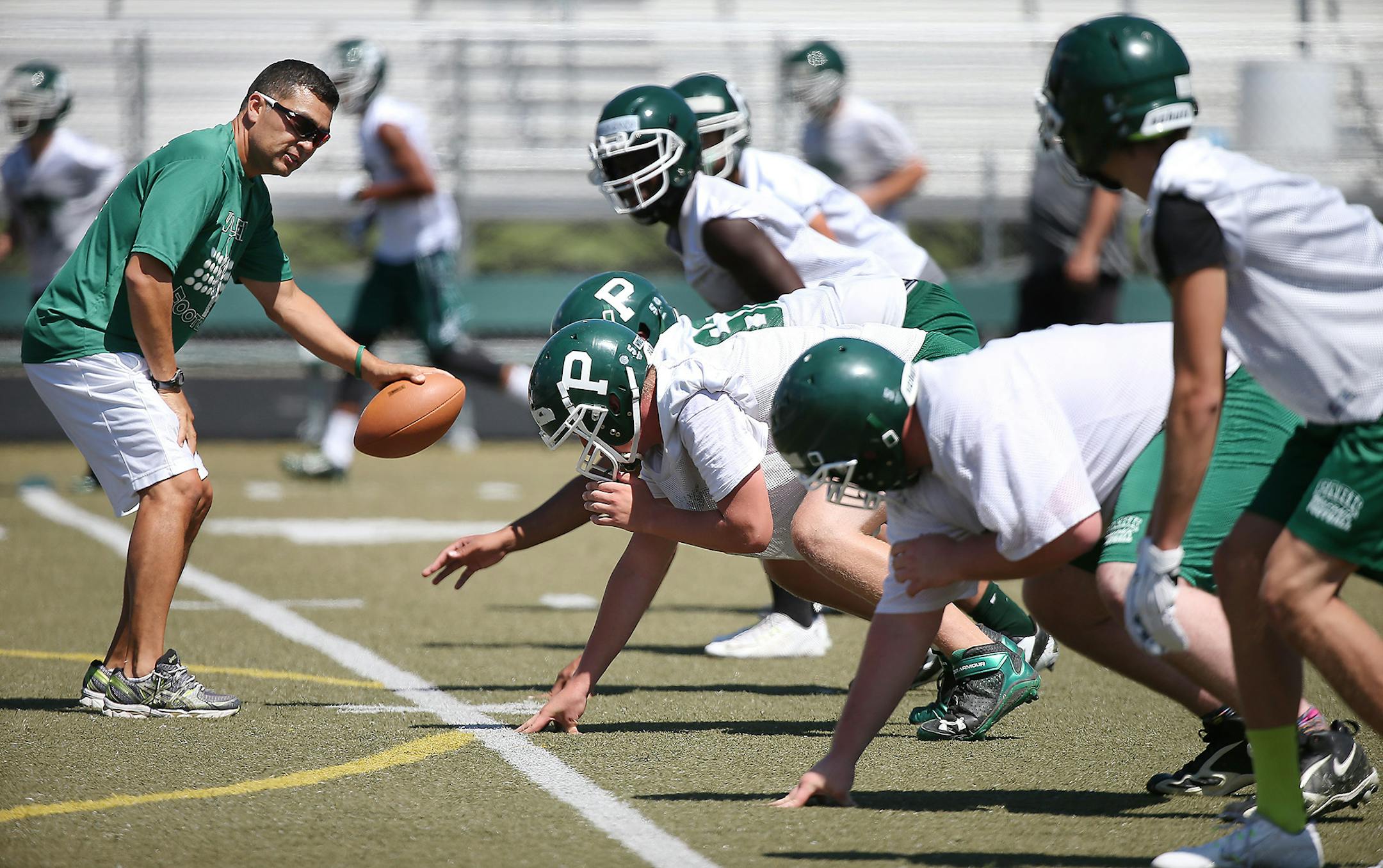 Assistant coach John McGowan led drills during the first day of football practice at Park of Cottage Grove.