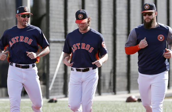 Houston Astros pitchers Justin Verlander, left, Gerrit Cole, center, and Dallas Keuchel jog as they warm up during spring training baseball practice T