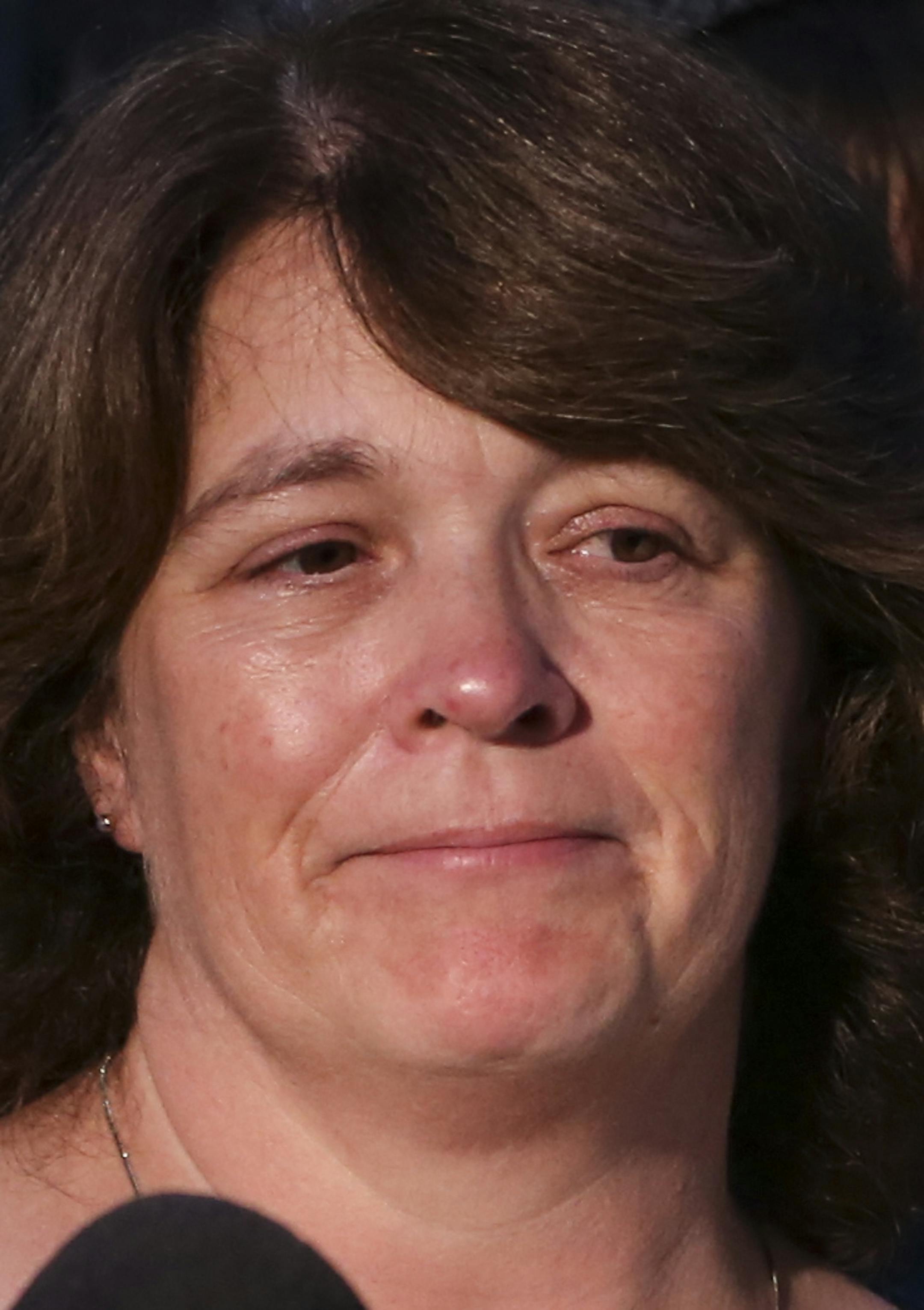 Michelle Patrick stood with her daughter's Erin, 19, and Amy, 14, as her brother-in-law Mike Brue spoke about his brother during a press conference at the scene of the shooting of Mendota Heights Officer Scott Patrick in West St. Paul, Minn., on Friday August 1, 2014.] RENEE JONES SCHNEIDER • reneejones@startribune.com