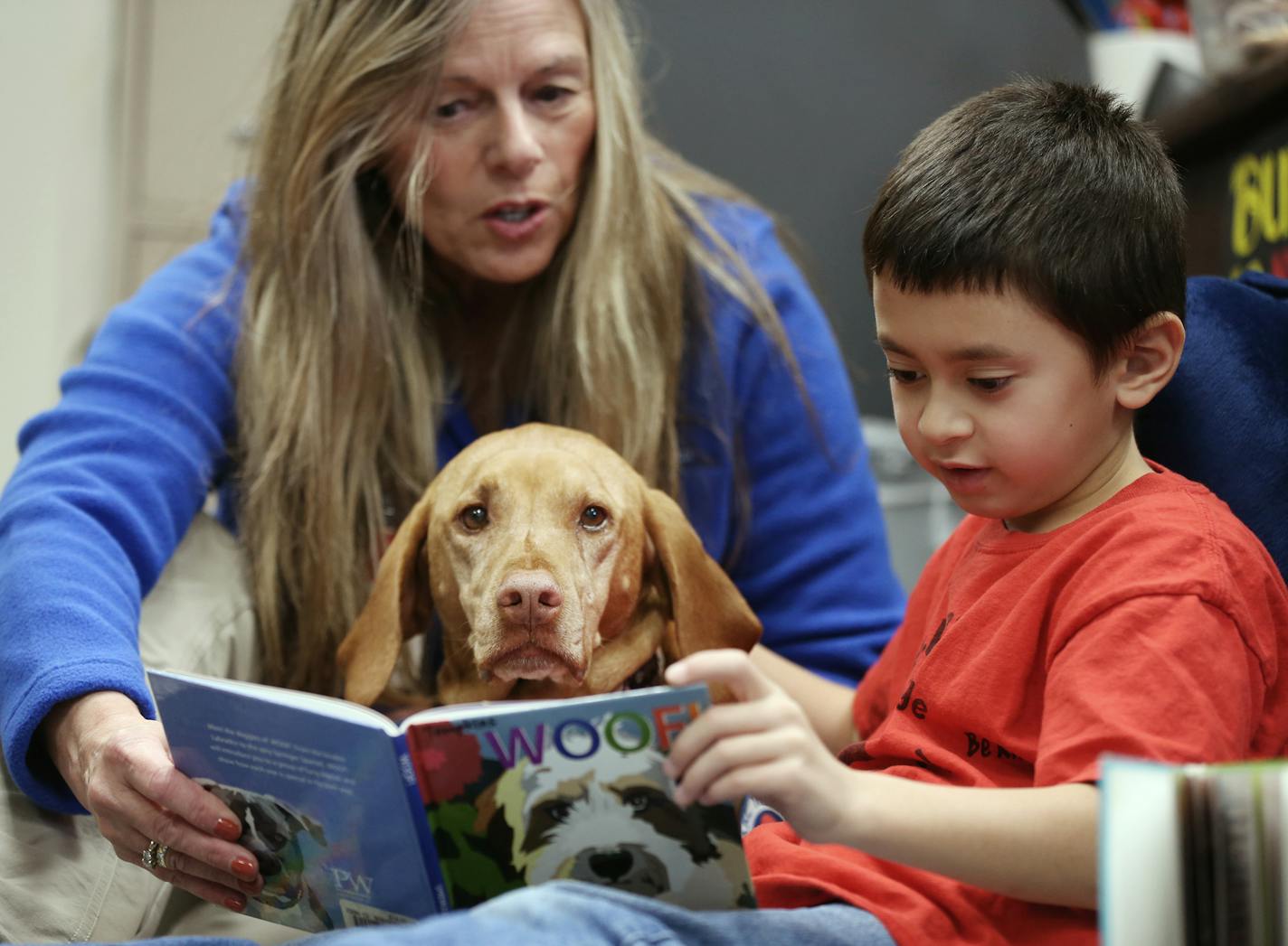 Kai Pat 7, read to Molly a Vizsla therapy dog, with her owner Connie Priesz at Cedar Ridge Elementary School Monday October 30,2017 in Eden Prairie, MN. ] JERRY HOLT &#xef; jerry.holt@startribune.com