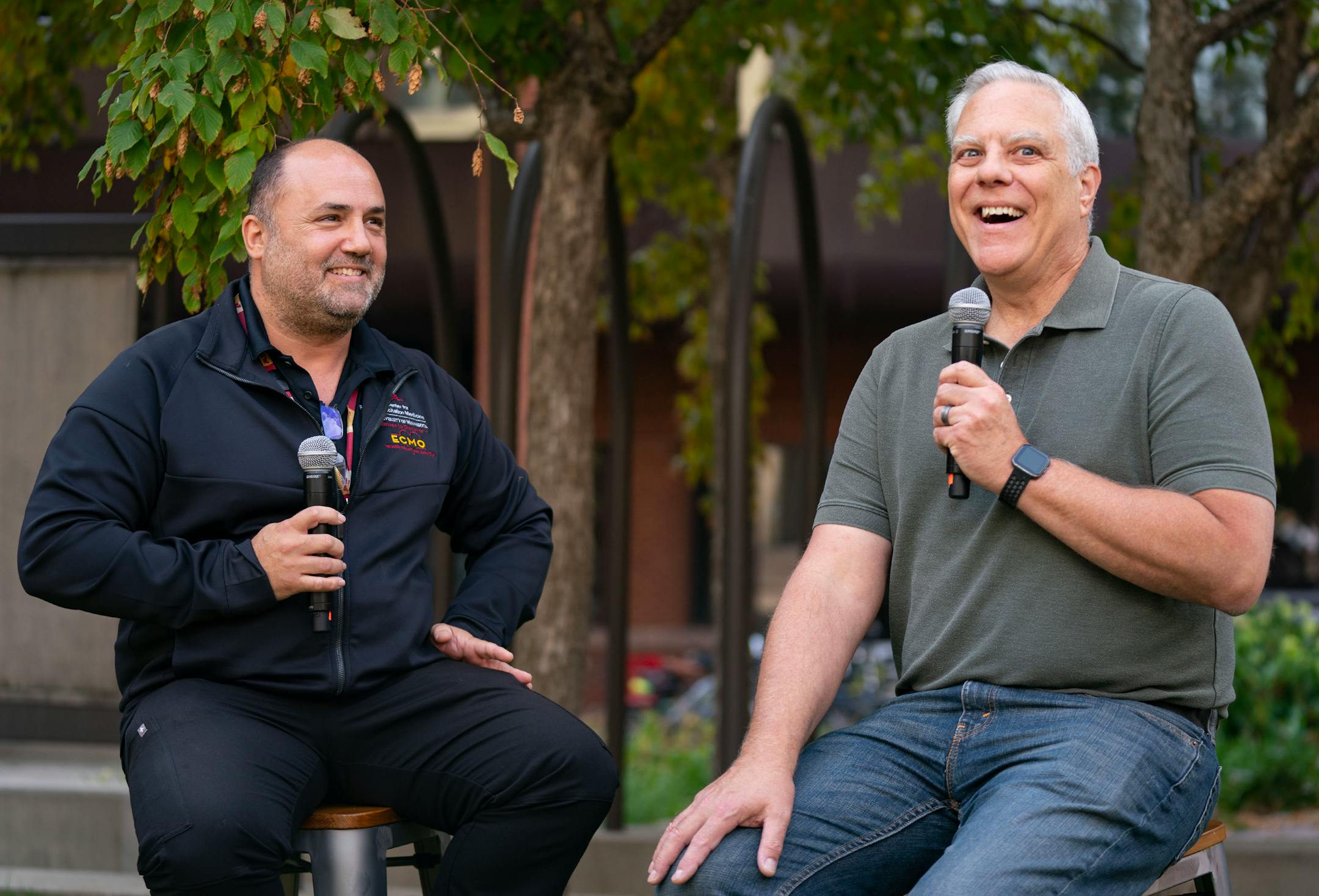 Demetris Yannopoulos, MD, director of the Center for Resuscitation Medicine, listens as John Sauer, a cardiac arrest survivor, shares his experience being a patient treated by portable ECMO during the M Health Fairview ECMO Center of Excellence Launch Event.