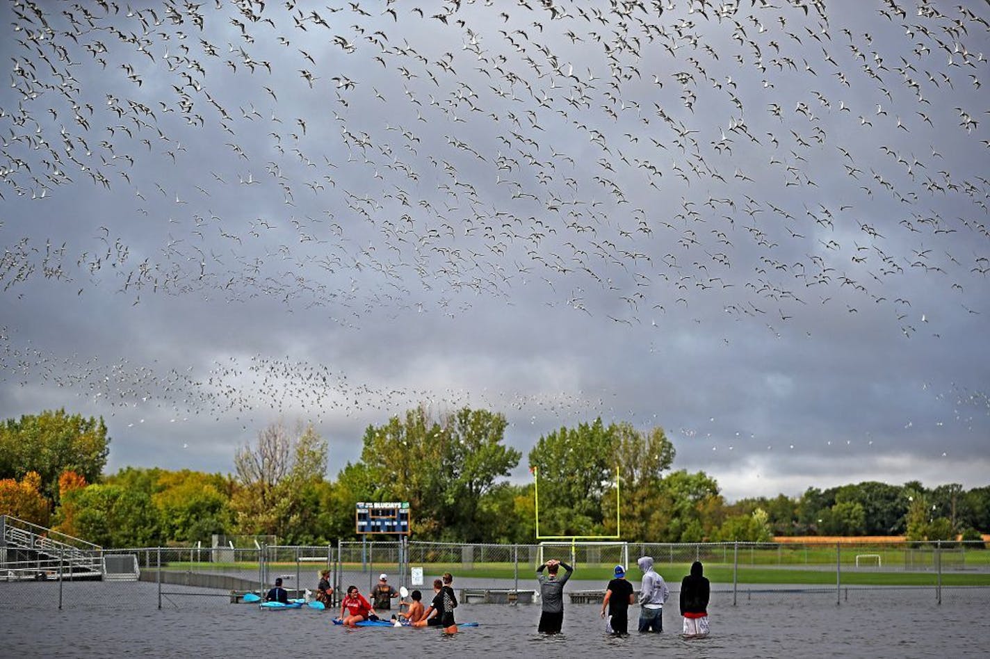 Waseca High football players checked out the flooding on their field near school on Thursday after 10 inches of rain fell on the area the past two days.