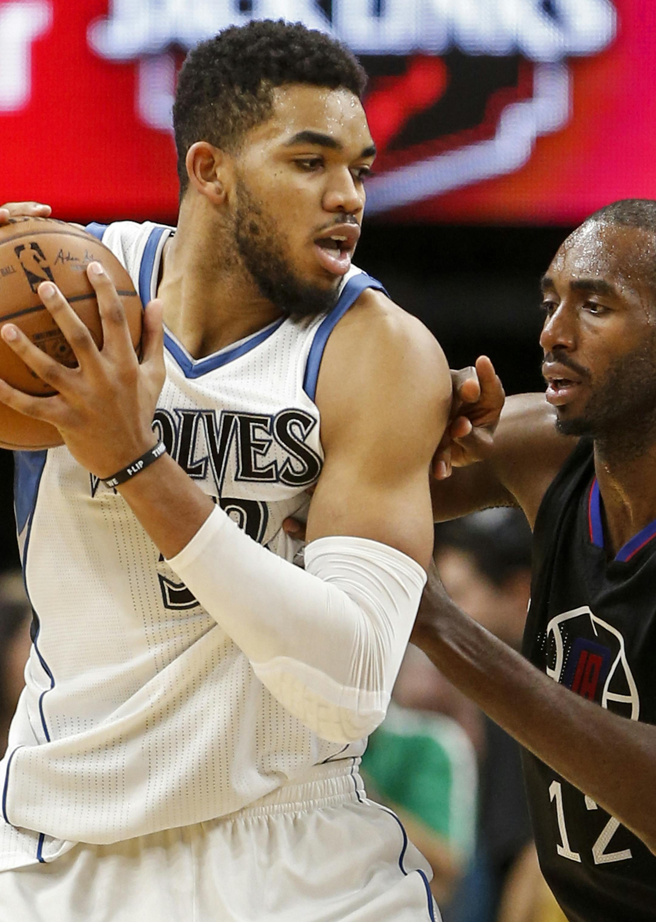 Minnesota Timberwolves center Karl-Anthony Towns (32) works against Los Angeles Clippers forward Luc Mbah a Moute (12) in the second half of an NBA basketball game Saturday, Nov. 12, 2016, in Minneapolis. The Clippers won 119-105. (AP Photo/Bruce Kluckhohn) ORG XMIT: MIN2016111418293446