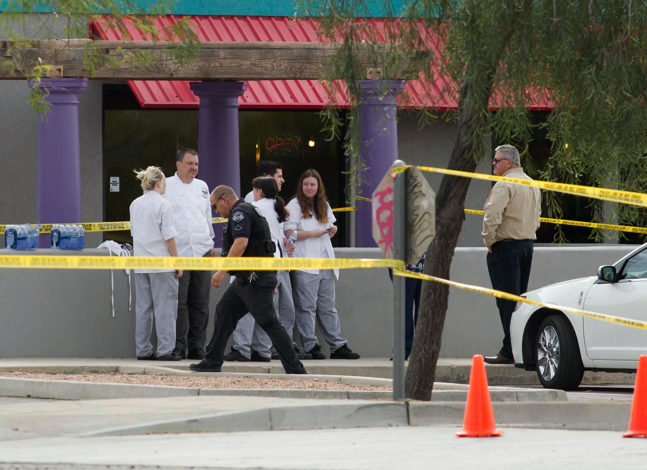 Mesa police talk to eyewitness at the scene of a shooting, Wednesday, March 18, 2015 in Mesa, Ariz. A gunman wounded at least four people across multiple locations in the Phoenix suburb and police warned residents to stay indoors as they hunt for the suspect. (AP Photo/The Arizona Republic, Nick Oza) MARICOPA COUNTY OUT; MAGS OUT; NO SALES