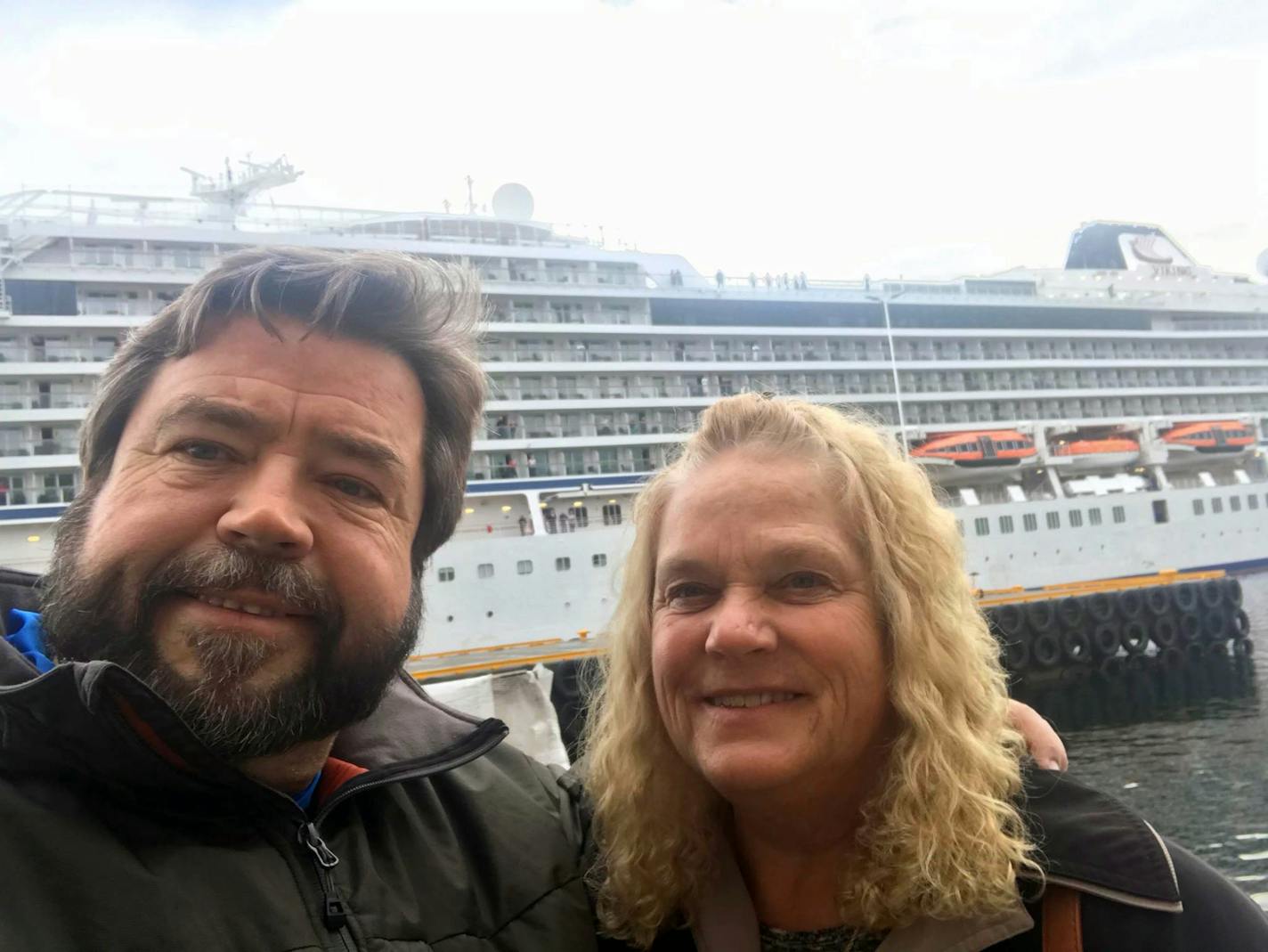 Rodney Horgen and Judy Lemieux, at their hotel in Molde, Norway. The troubled ship they were on is in the background.