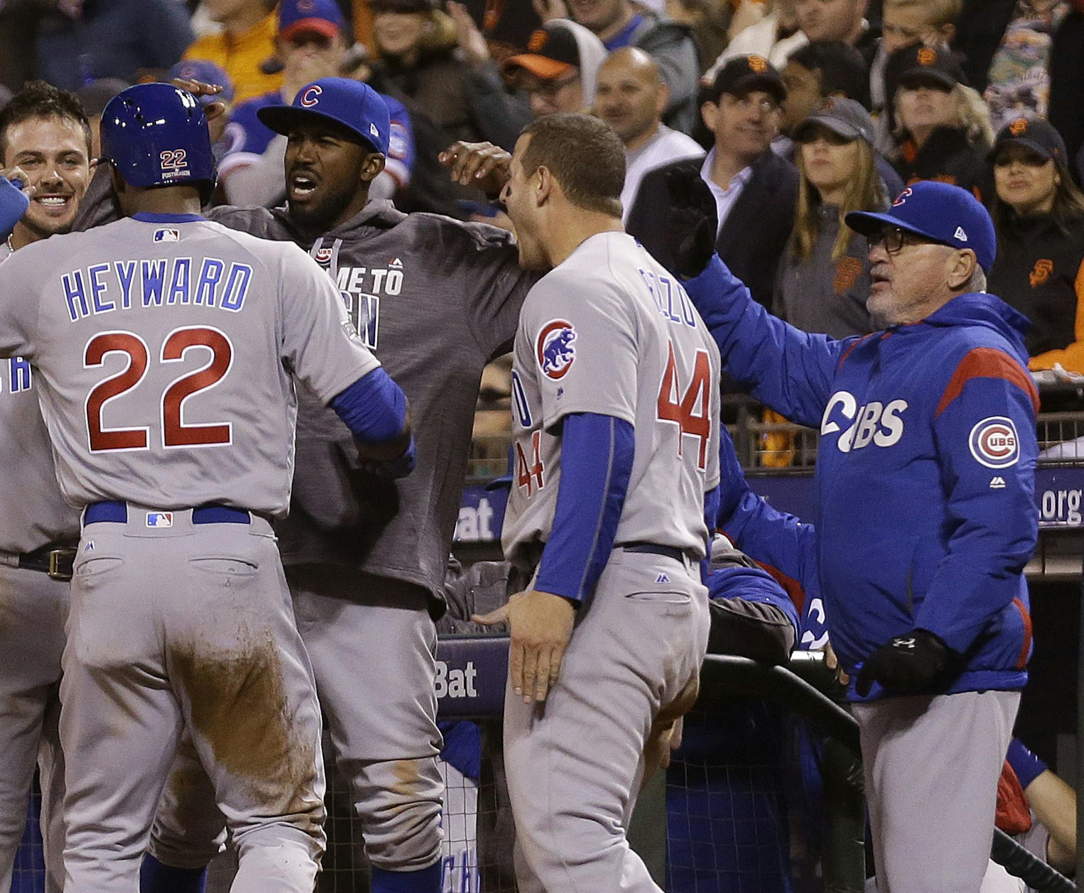 Chicago Cubs' Jason Heyward (22) celebrates after scoring with Kris Bryant, from left, Dexter Fowler, Anthony Rizzo and manager Joe Maddon during the ninth inning of Game 4 of baseball's National League Division Series against the San Francisco Giants in San Francisco, Tuesday, Oct. 11, 2016. (AP Photo/Ben Margot)
