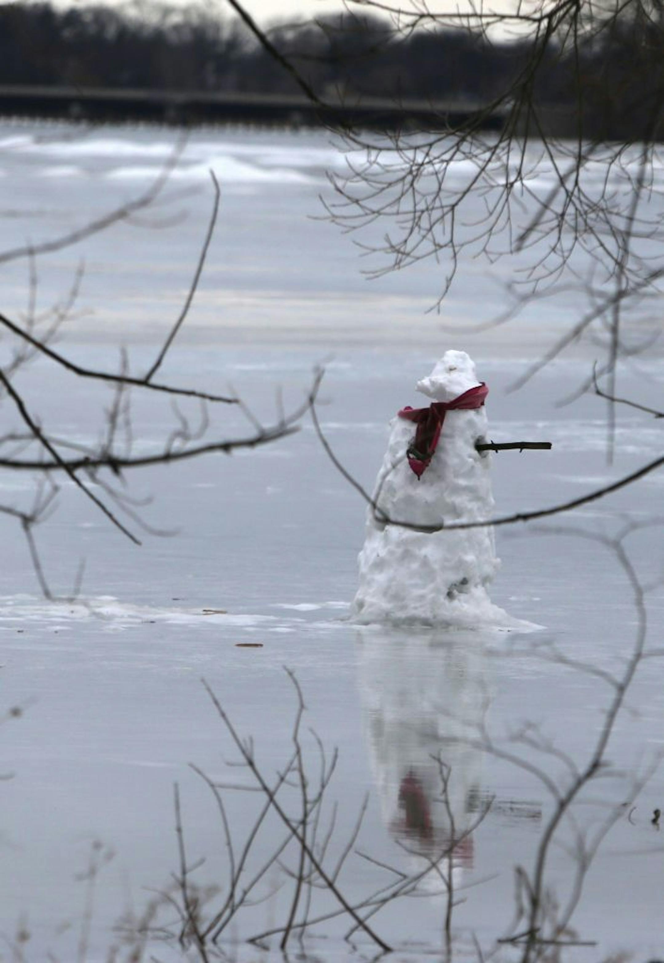A snowman on Lake Nakomis begins to melt into the lake after a morning of warm temps and rain Friday, Feb. 19, 2016, in Minneapolis, MN.