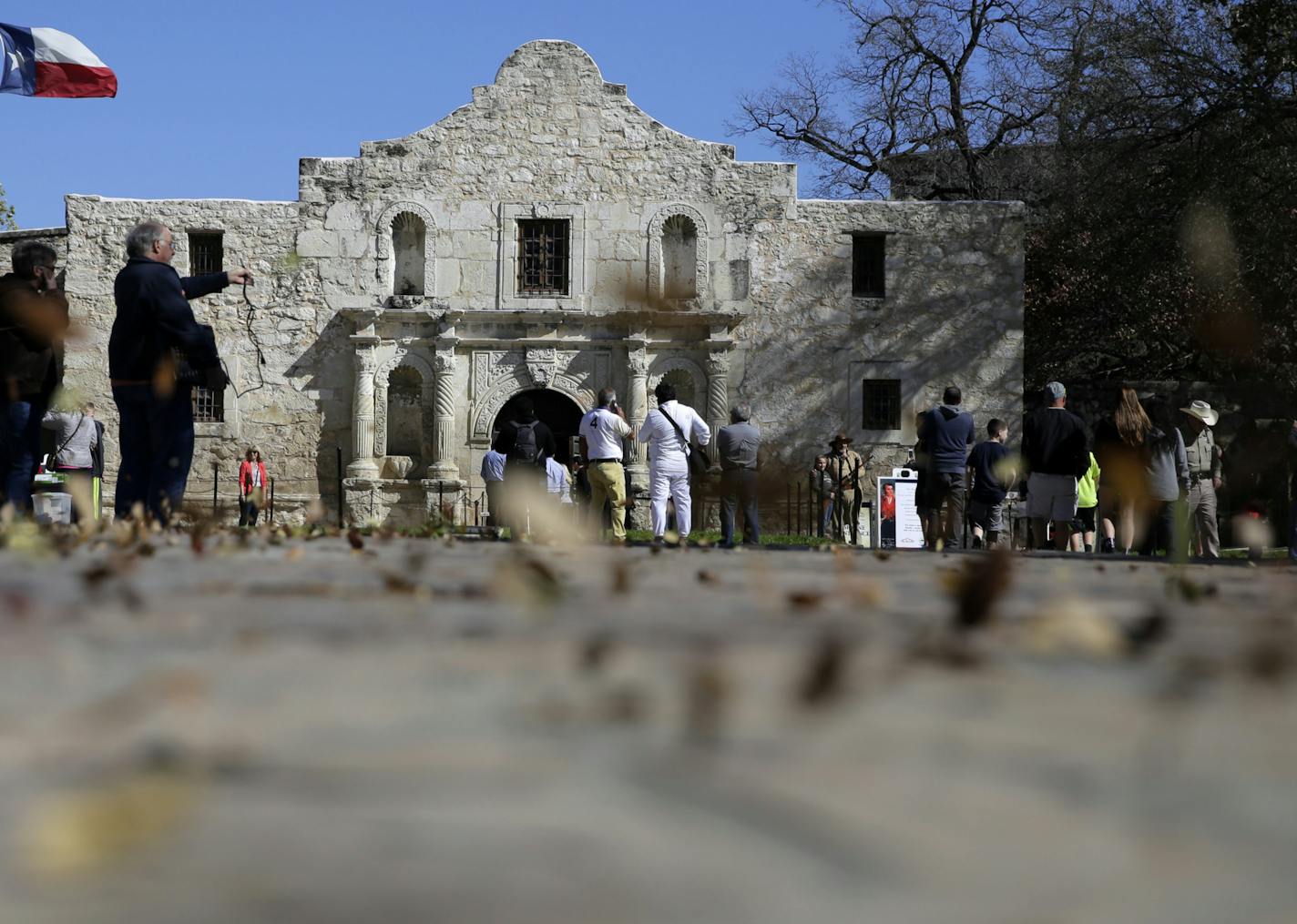 FILE - In this Feb. 23, 2016, file photo, guests visit the grounds of the Alamo in San Antonio. Texas Land Commissioner George P. Bush is overseeing a 7-year, $450 million revamp of the Alamo, where 189 independence fighters were killed in 1836. That includes restoration of historical structures and building a new museum and visitors' center. But some conservatives worry that the importance of the battle for the Alamo will be marginalized by "political correctness," with the overhaul sanitizing