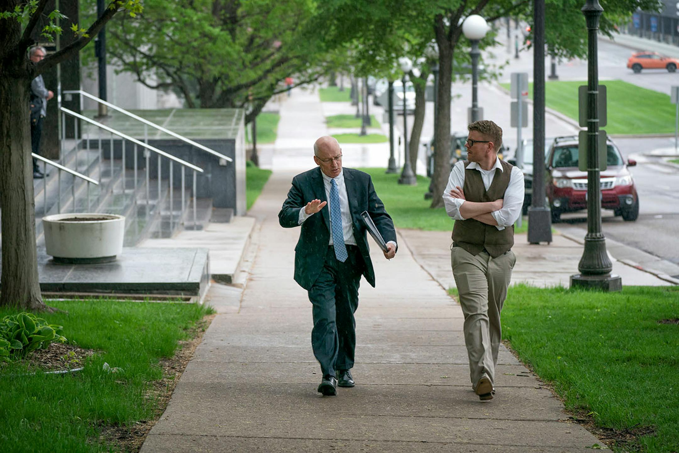 MMB Commissioner Myron Frans walked in the rain to an evening Senate Finance Committee meeting with Keith Hovis, communications director for MMB.