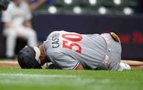 The Twins' Willi Castro stays on the ground after fouling a ball off his leg during the first inning Friday. He was removed from the game after one mo