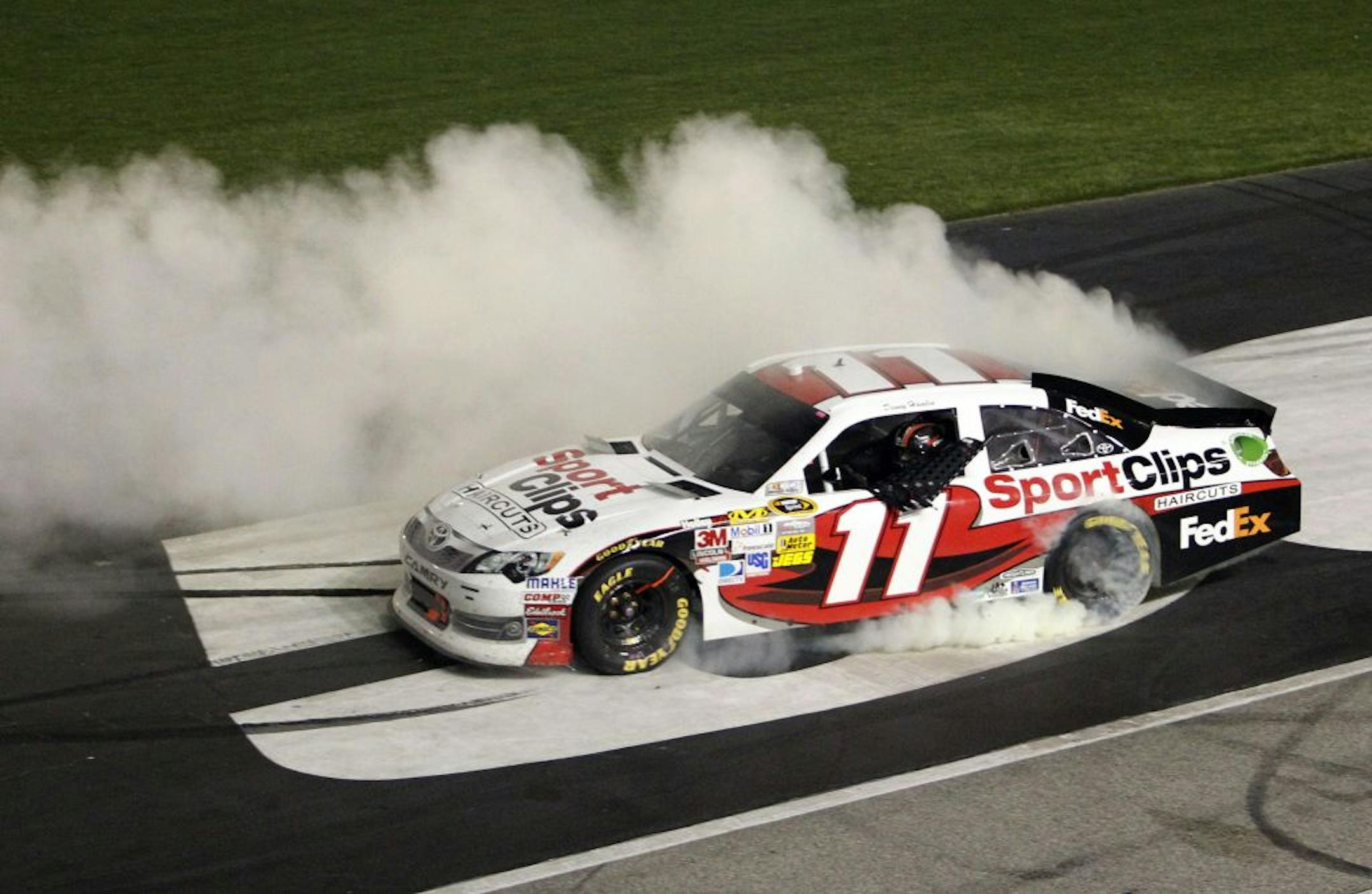 Denny Hamlin does a burnout to celebrate his NASCAR Sprint Cup Series auto race victory at Atlanta Motor Speedway