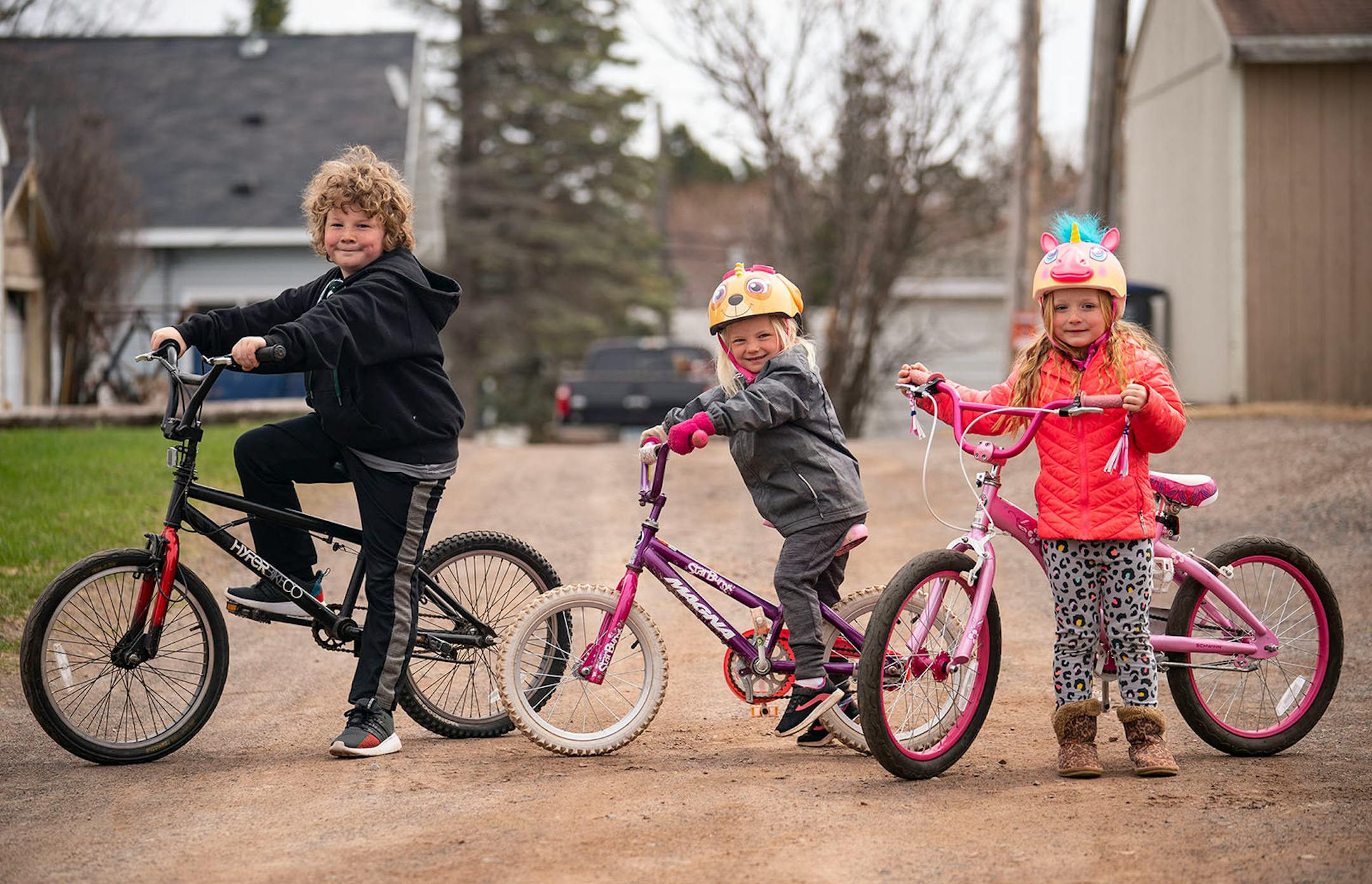 Joe Fahlin, 9, Anna, 4, and Abby, 5, posed for a portrait with their bikes in Cloquet. The trio of siblings love riding their bikes together around the block and neighborhood.