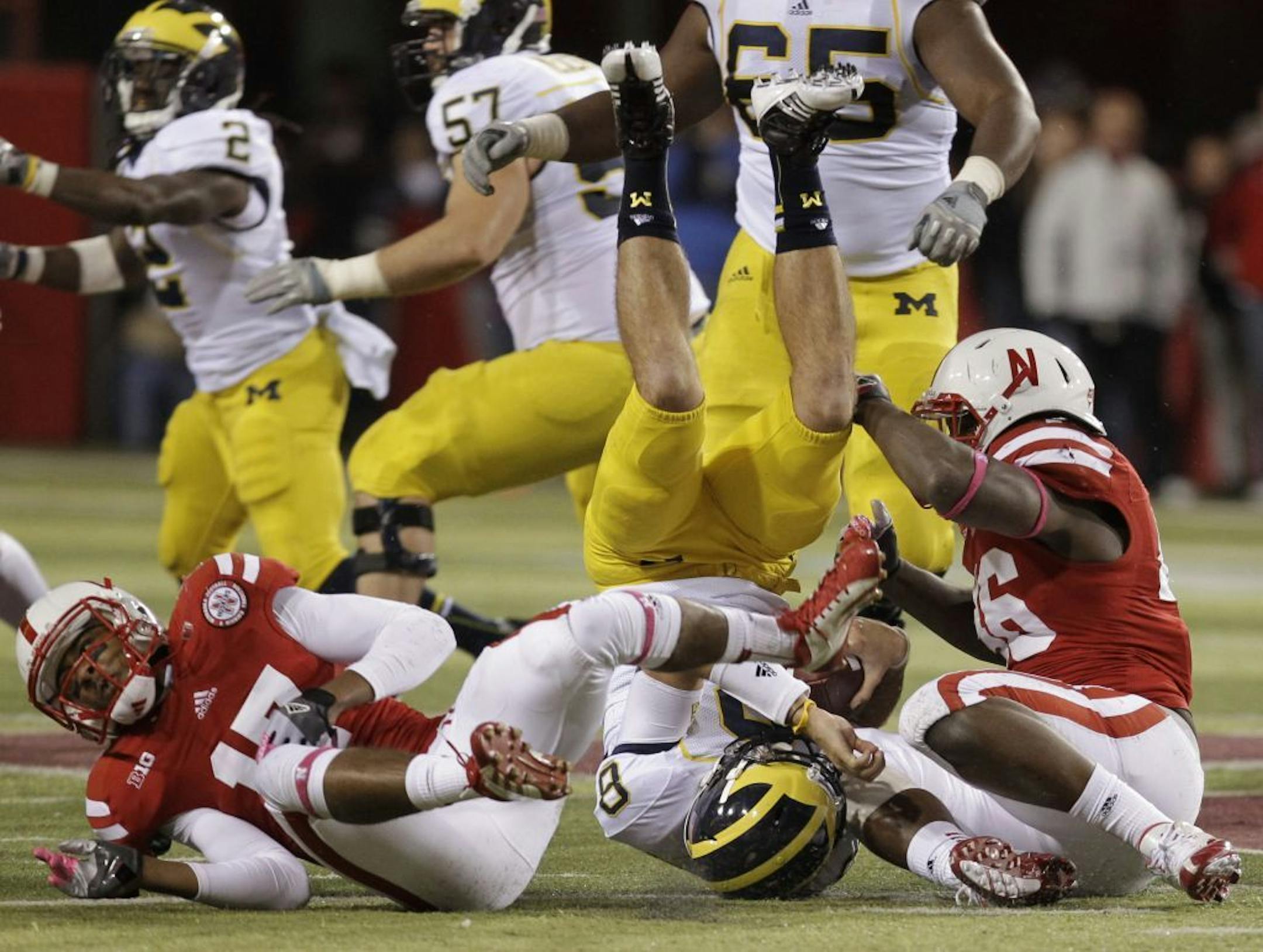 Michigan quarterback Russell Bellomy, center, is upended as he is sacked by Nebraska's Ciante Evans, left, and Eric Martin on Oct. 27.