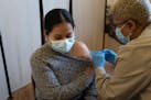 A health care worker administers a COVID-19 vaccine in New York, April 5, 2021.