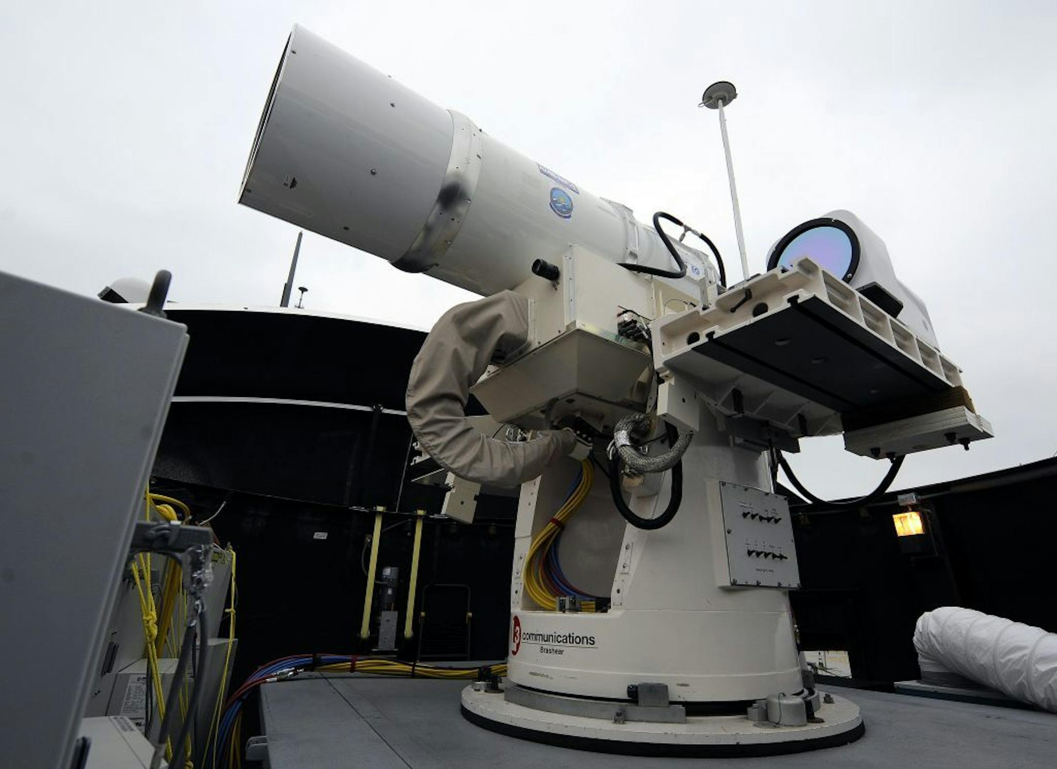 In this July 30, 2012 photo provided by the U.S. Navy, a laser weapon sits temporarily installed aboard the guided-missile destroyer USS Dewey in San Diego. The Navy plans to deploy its first laser on a ship in 2014, and intends to test an electromagnetic rail gun prototype aboard a vessel within the following two years.