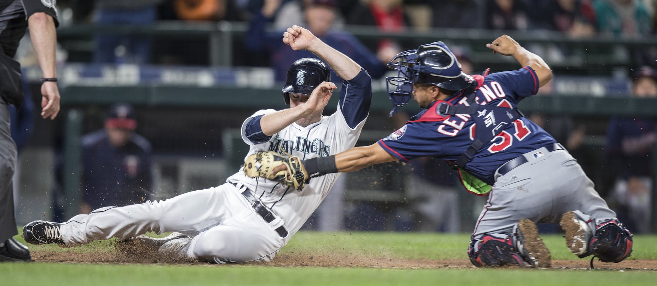 Seattle Mariners' Seth Smith, left, is tagged out at home plate by Minnesota Twins catcher Juan Centeno during the sixth inning of a baseball game Saturday, May 28, 2016, in Seattle. (AP Photo/Stephen Brashear)