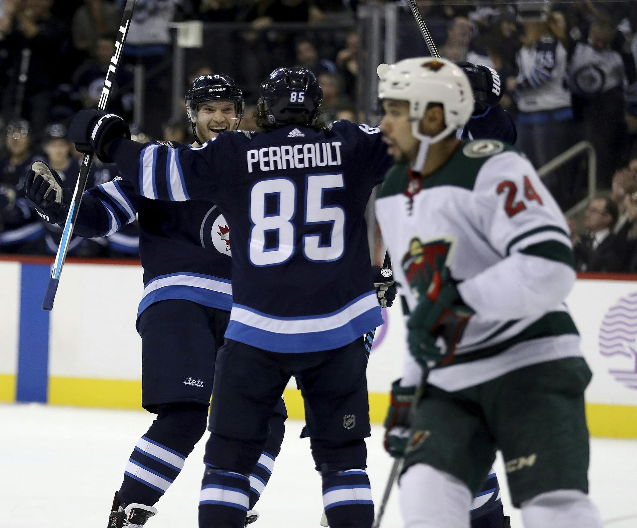 Winnipeg Jets' Joel Armia (40) and Mathieu Perreault (85) celebrate after Perreault scored during second period NHL hockey action against the Minnesota Wild, in Winnipeg on Monday, Nov. 27, 2017. (Trevor Hagan/The Canadian Press via AP)
