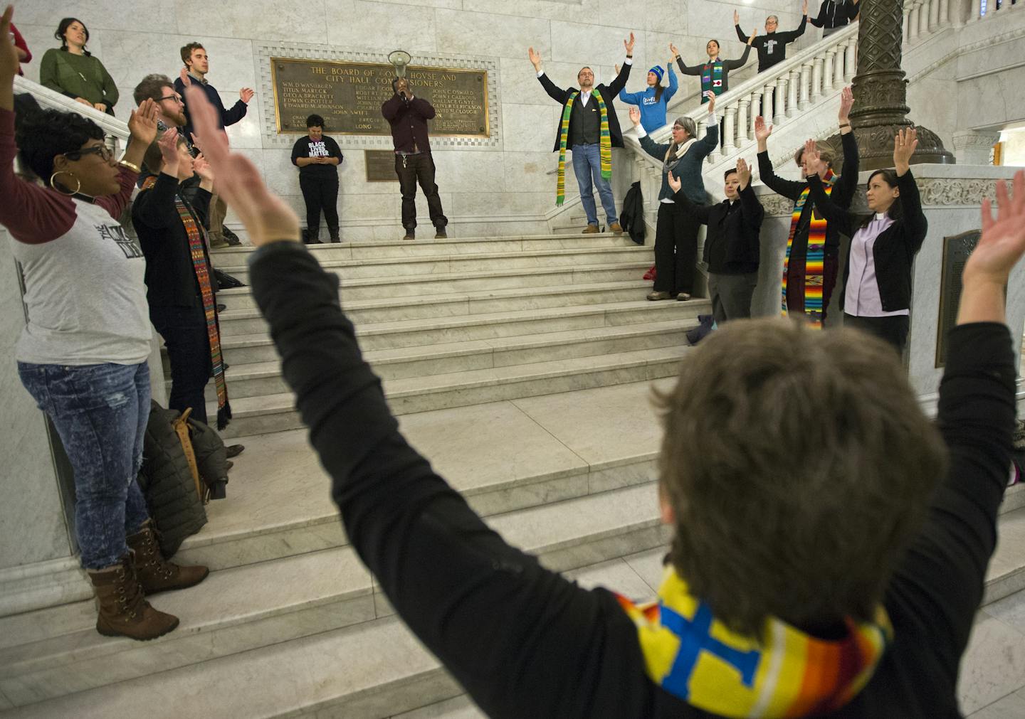 Dozens of clergy from parishes around the Twin Cities, including Pastor Rebecca Voelkel of Lyndale United Church of Christ (foreground) gathered in the Minneapolis City Hall rotunda Tuesday morning demanding the release of the video of the shooting of Jamar Clark. ] Minneapolis, MN - 12/01/2015