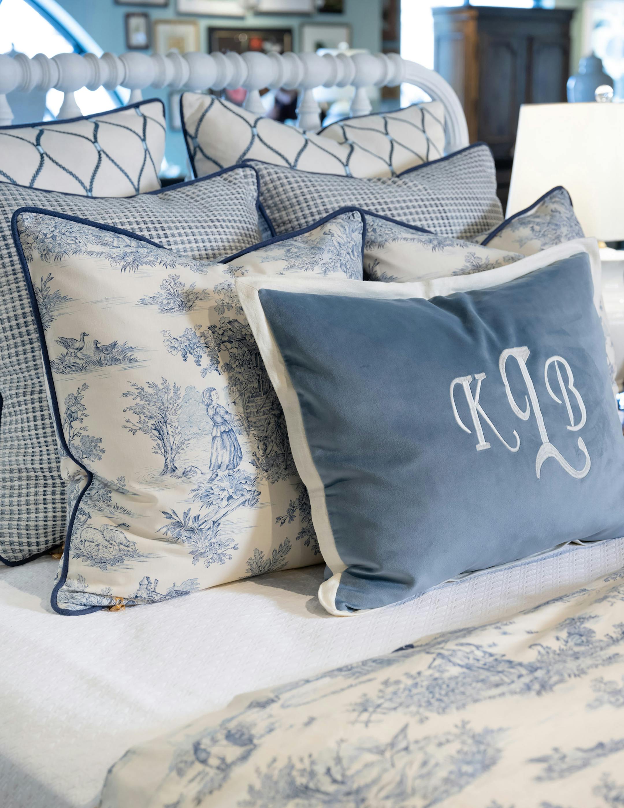 A classic blue and white traditional toile is the focal fabric for this bedding look that combines creams, whites, and multiple shades of blue for a refined yet relaxed bed. (Handout/TNS)