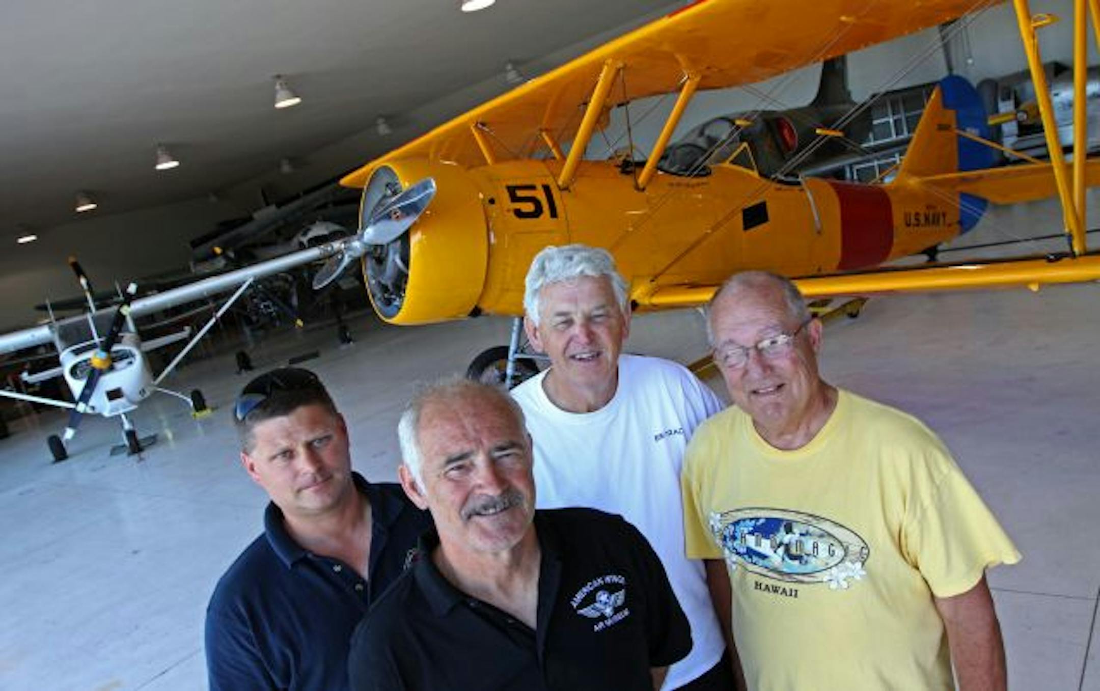 (left to right) LTJG. Mike Gorecki, (training office for the Poseidon Division of the Sea Cadets, Don Larson (American Wings Air Musuem), Stan Rosand (American Wings Air Museum Board of Directors) and LT. Ed Mitchell (Sea Cadets, Poseidon Division Commanding Officer) were photographed infront of a 1940's Navy N3N3 trainer at the American Wings Air Museum at Anoka County-Blaine Airport. The museum, started in the late 1980's, has until the end of the month to sell its hanger or be evicted by the
