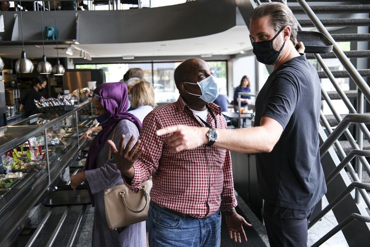 Omar Jamal, who works with the Ramsey County Sheriff's Department, spoke to Cafe Latte co-owner Bryce Quinn as he went through line Wednesday to get lunch with a friend. Jamal is concerned that government messaging about masks isn't effectively making its way to elderly, medically vulnerable immigrants.