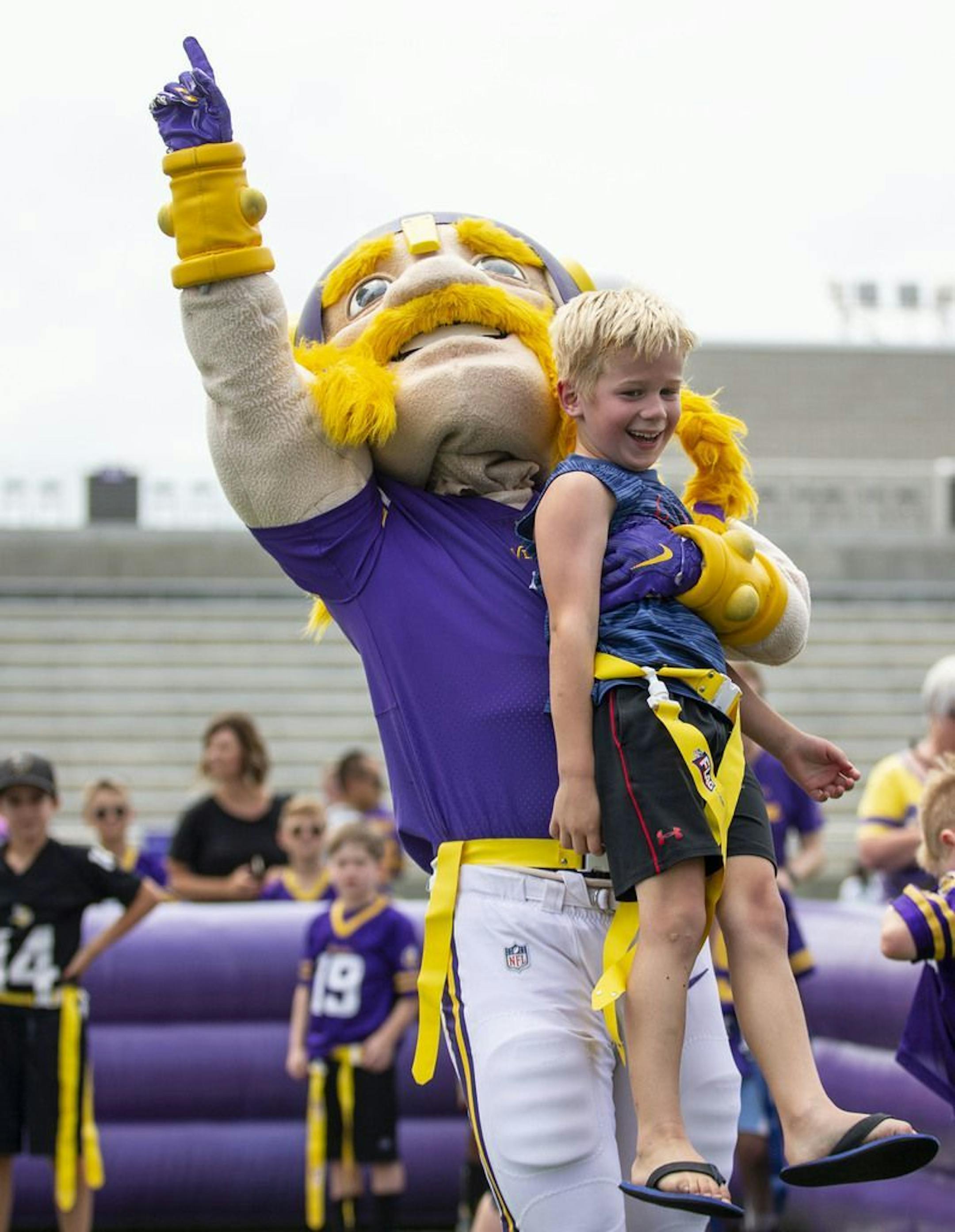 Viktor the Viking, the Minnesota Vikings mascot, lifted up Owen Johnson in celebration after he scored a touchdown in a small flag football game in the Kid's Zone at Vikings training camp. ALEX KORMANN • alex.kormann@startribune.com The Minnesota Vikings opened up their first full day of training camp on Friday July 26, 2019 at TCO Performance Center in Eagan, MN. Doors opened to fans at 11AM to watch their favorite players practice and get excited for the 2019 NFL season.