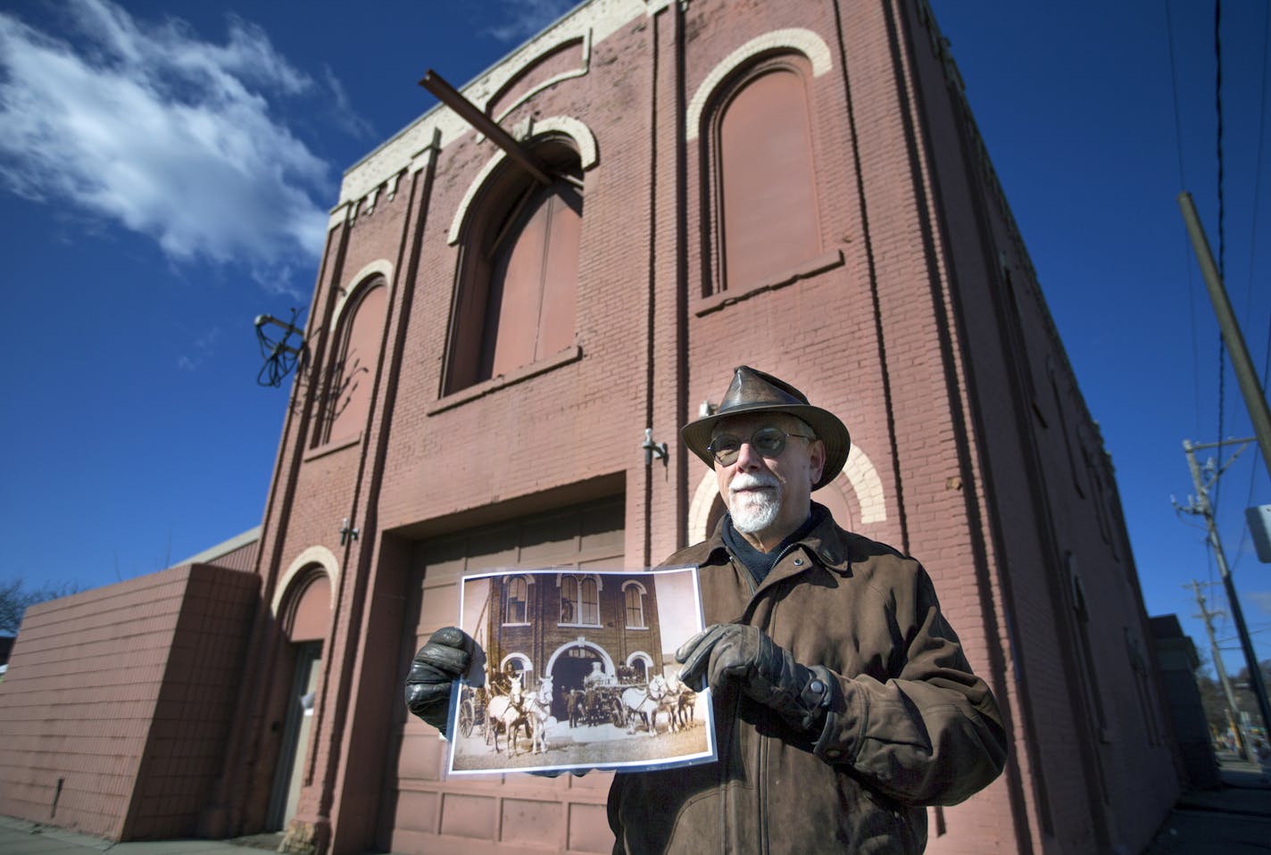 Historian Jim Sazevich held an old photo of the Hope Engine Company No. 3 firehouse in front of the building. — which dates back to 1872.