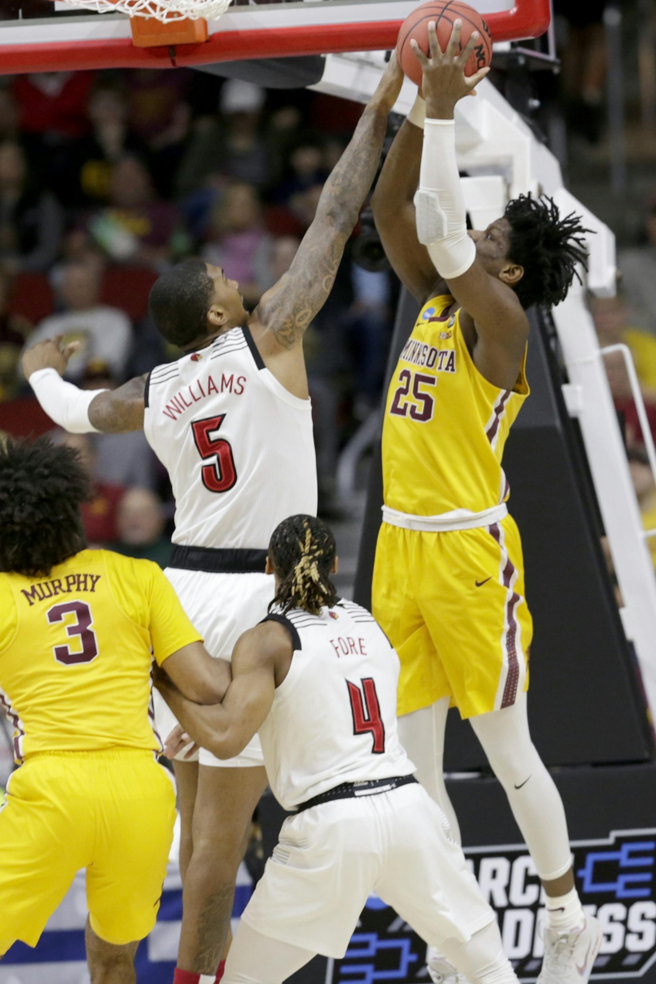 Louisville's Malik Williams (5) fouls Minnesota's Daniel Oturu (25) during the first half of a first round men's college basketball game in the NCAA Tournament, in Des Moines, Iowa, Thursday, March 21, 2019.
