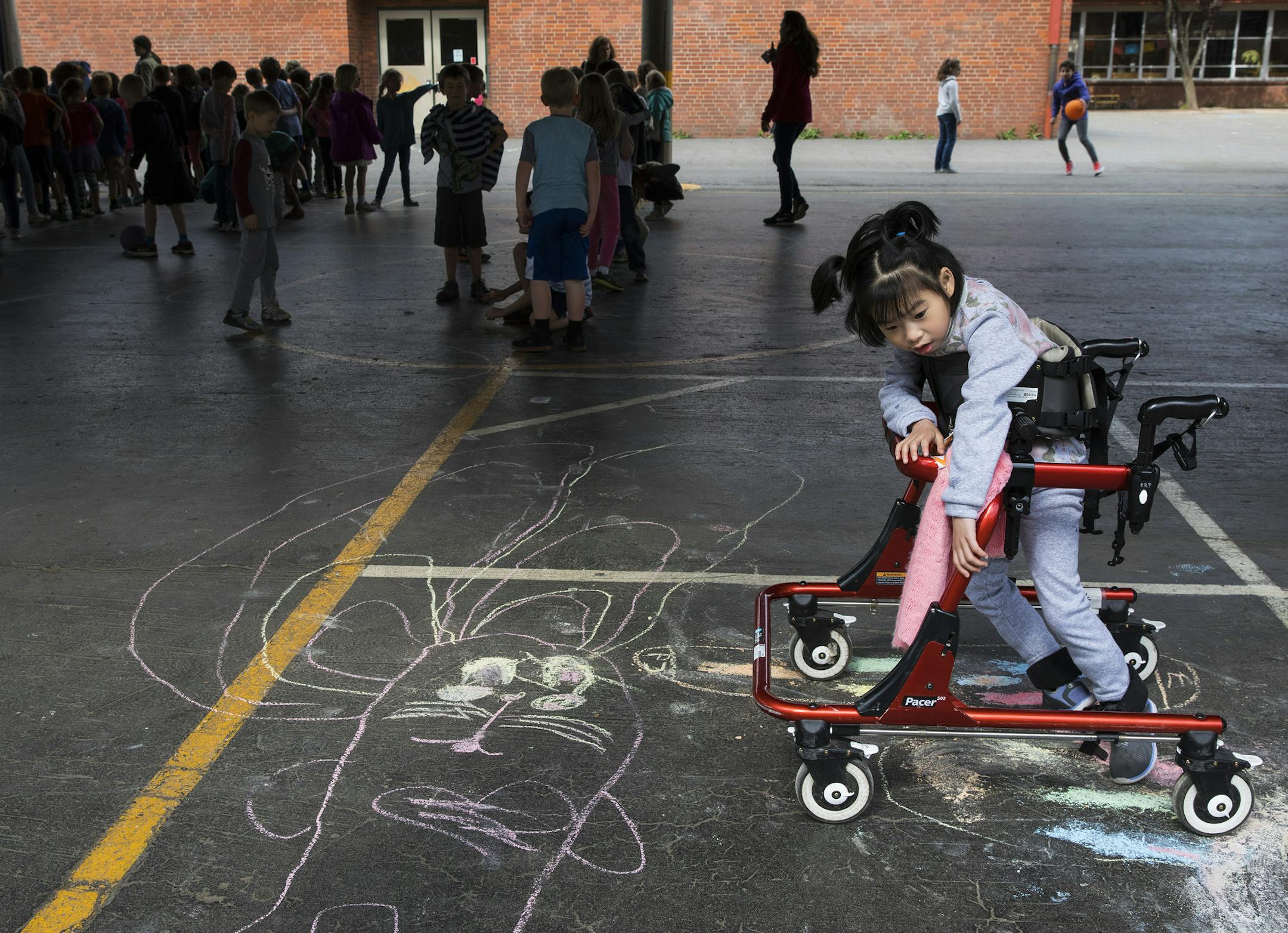 Yuna Lee, who has a rare defect on the FOXG1 gene, during playtime at Bridlemile Elementary School in Portland, Ore., May 25, 2017. Yunaís mother, Soo-Kyung Lee, who had worked with the FOX family of genes for years, began doing what she was uniquely positioned to do: aiming her research squarely at her daughterís disorder. (Ruth Fremson/The New York Times)