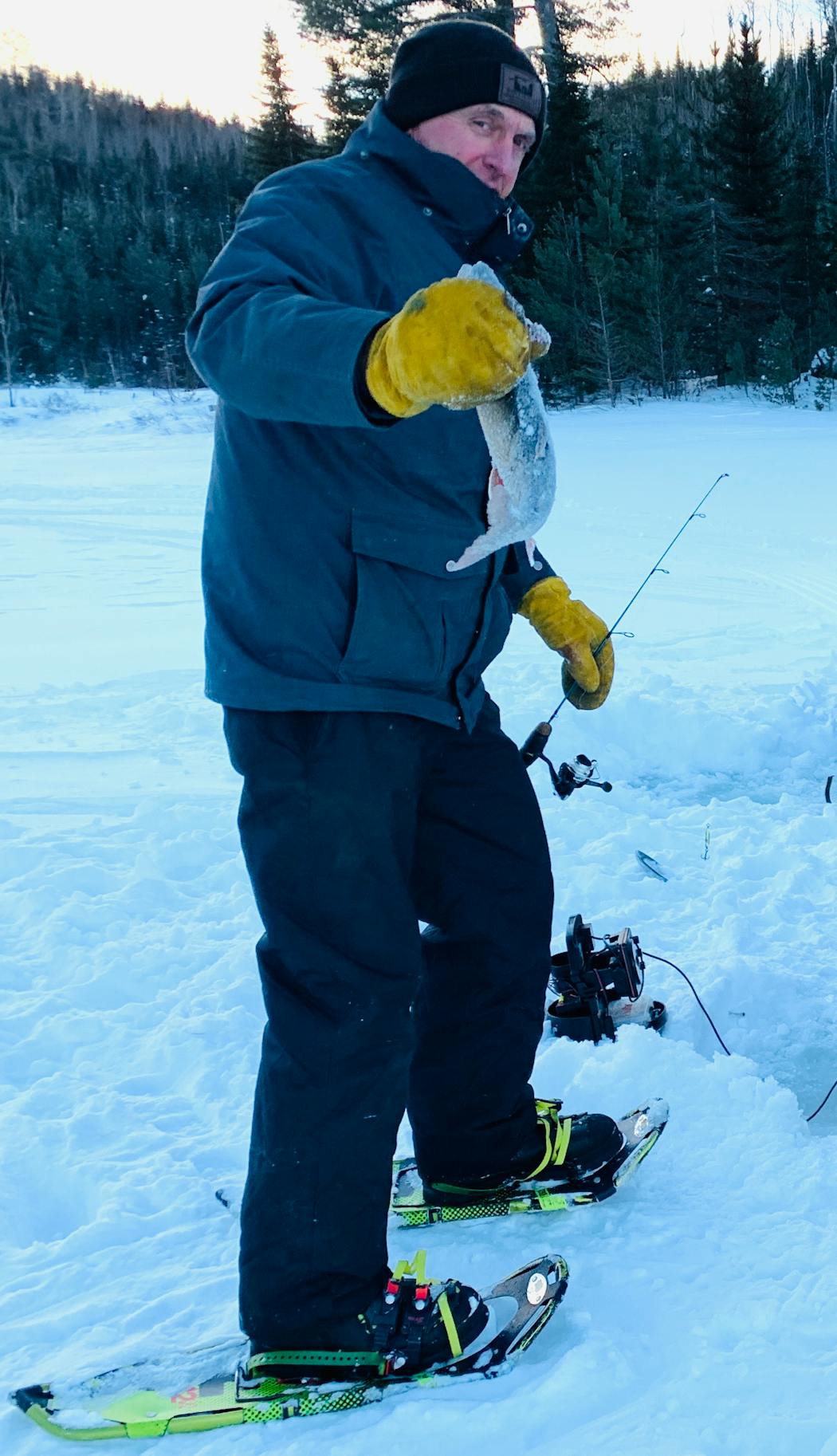 Snowshoe-clad Terry Arnesen of Stillwater with a dandy lake trout caught through the ice on a lake off the Gunflint Trail.