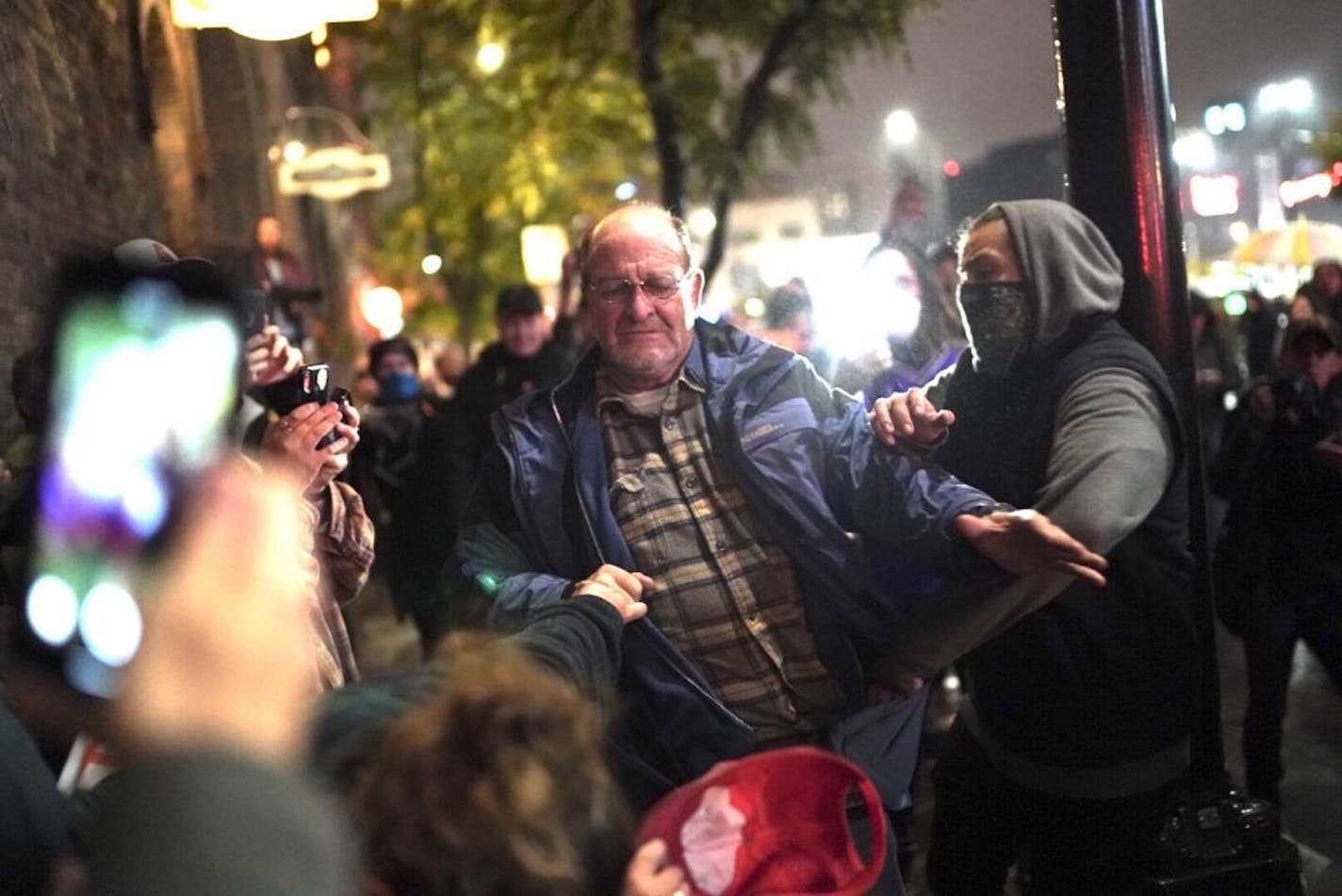 A Trump supporter got in a fight with a protester after his hat was grabbed off his head outside the Target Center after President Donald Trump visited Minneapolis, Minn., for a campaign rally on October 10, 2019. The fight appeared to escalate when he started saying "hang Obama."