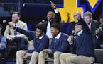 Michigan head football coach Jim Harbaugh sits with recruits Donovan Peoples-Jones and Tarik Black after they are introduced during the "Signing of th
