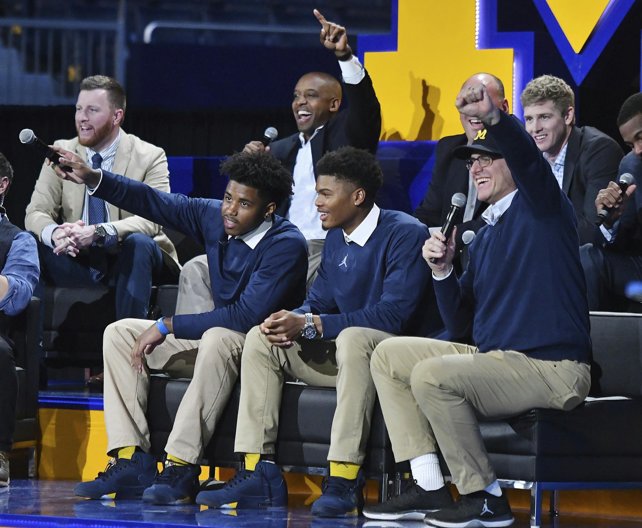 Michigan head football coach Jim Harbaugh sits with recruits Donovan Peoples-Jones and Tarik Black after they are introduced during the "Signing of the Stars" event on national signing day at Crisler Center in Ann Arbor, Mich., Wednesday, Feb. 1, 2017. (Daniel Mears/Detroit News via AP)