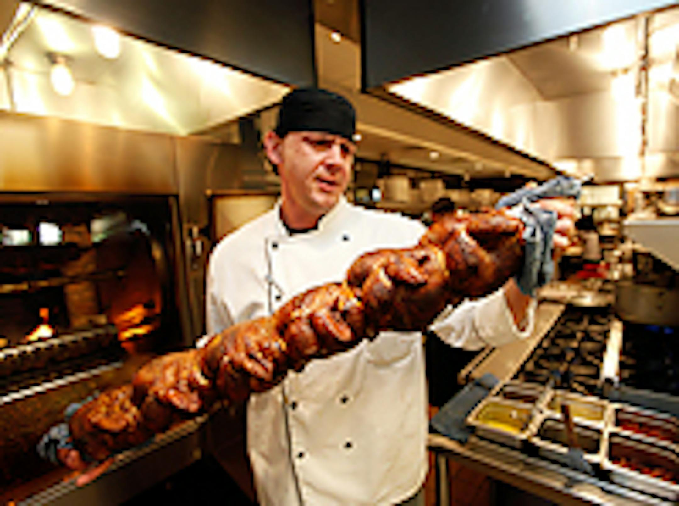 Cad Duda takes finished chickens out of the pit