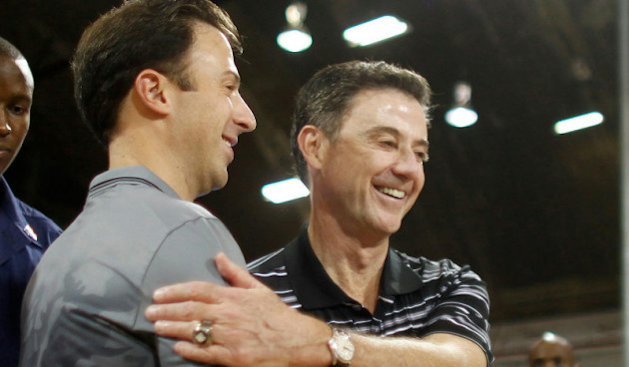 "Minnesota head coach Richard Pitino, front left, greets his father, Louisville head coach Rick Pitino, before the start of their NCAA college basketball Armed Forces Classic game inside a hangar at the United States Coast Guard Air Station base in Aguadilla, Puerto Rico, Friday, Nov. 14, 2014. (AP Photo/Ricardo Arduengo)"