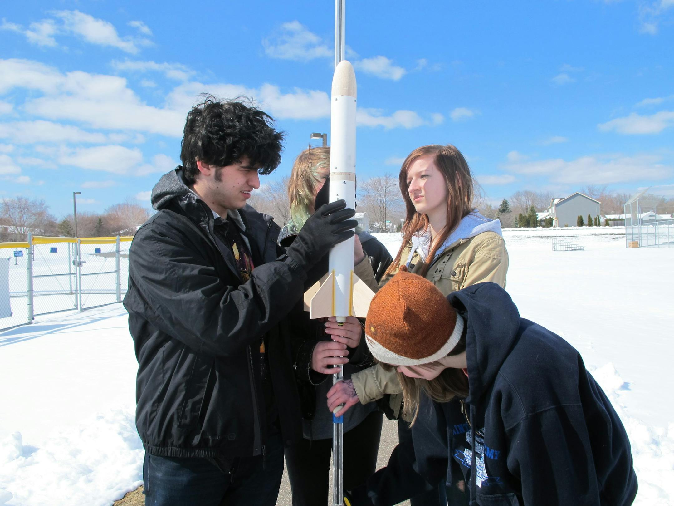 Photo by Erin Adler Rocket team members Eduardo Boeing, Tori LaBonte, Maren Connell and Gabby Edwards get the rocket ready for launching. They attach it to a pole so it has a better chance of flying straight. 4/22/13