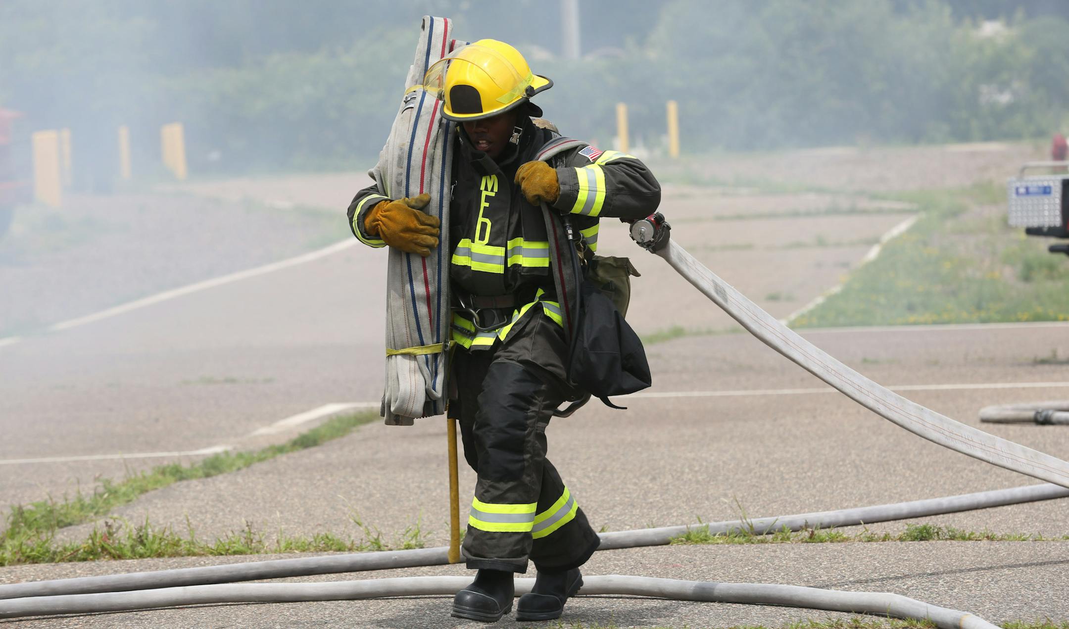 Cadet Kenneth Glenn carried over more hose during a skills event in front of family and friends as a part of the graduation ceremony. ] (KYNDELL HARKNESS/STAR TRIBUNE) kyndell.harkness@startribune.com At the NE Emergency Operations Training Facility in Minneapolis, Min. Friday, July 11, 2014. Of the 19 newly minted Minneapolis firefighters, 18 of them are veterans. We talk to some of them and find out if this is part of a concerted effort to hire veterans.