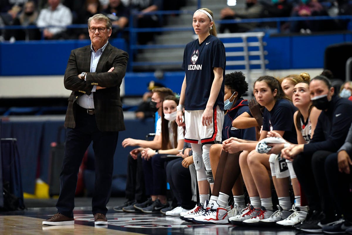 Connecticut coach Geno Auriemma and Paige Bueckers watch during the first half of the team's game against Marquette on Feb. 23