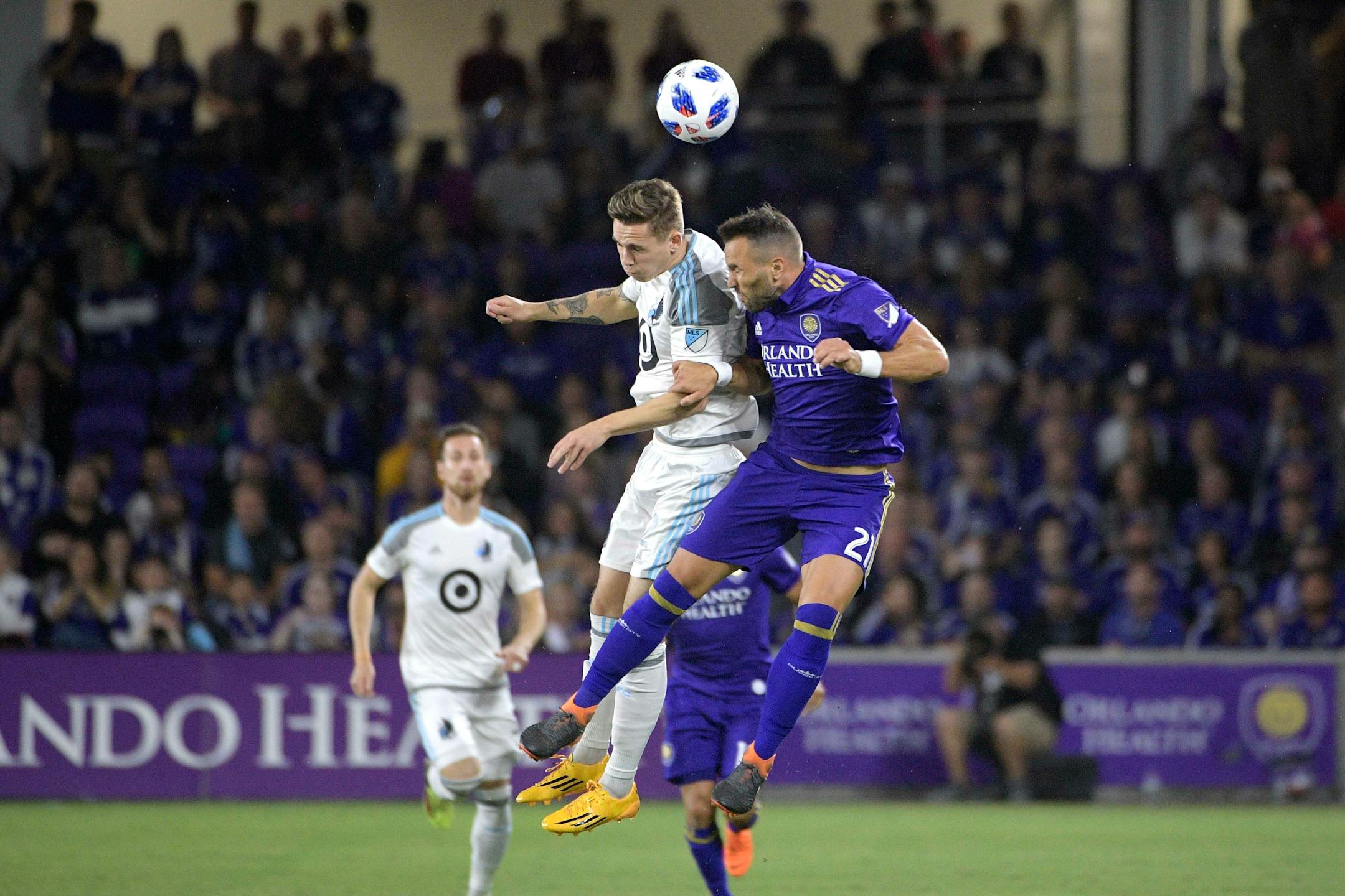 Minnesota United midfielder Sam Nicholson (12) and Orlando City midfielder Scott Sutter (21) battle for a header during the first half of an MLS soccer match Saturday, March 10, 2018, in Orlando, Fla. Minnesota won 2-1. (Phelan M. Ebenhack for the Star-Tribune) ORG XMIT: OTKMINN123