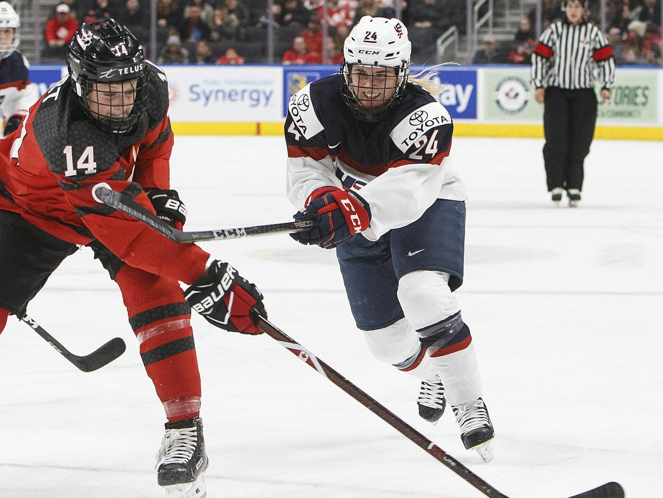 Team Canada's Renata Fast (14) is slashed by Team USA's Dani Cameranesi (24) during first period National Women's Team series hockey action in Edmonton, Alberta, on Sunday Dec. 17, 2017. (Jason Franson/The Canadian Press via AP)