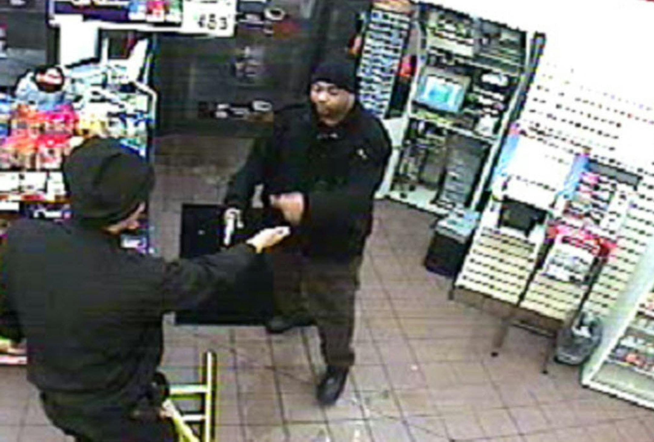 In this screen grab from surveillance video, a gunman is seen confronting an armored truck guard filling an ATM inside a Super America in St. Paul on Jan. 14, 2011. Video provided by the FBI.