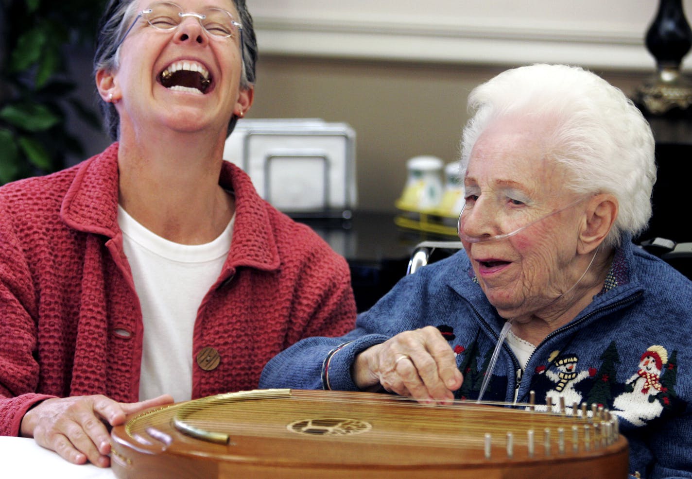 Chaplain Ann Bergstrom, left, shared a laugh with Grace Smith as they played the Reverie Harp at Walker Elder Suites Wednesday, Nov. 26, 2008. Bergstrom said she plays the harp for residents at Walker Elder Suites two days a week.