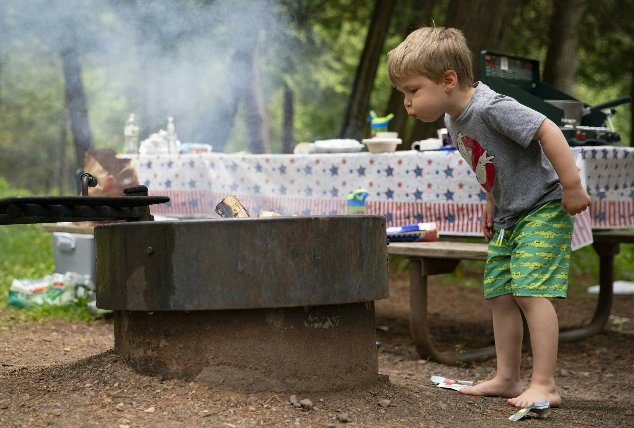 Tommy McLafferty (5) blew on the fire his father had made at their campsite in Jay Cooke State Park on Wednesday.